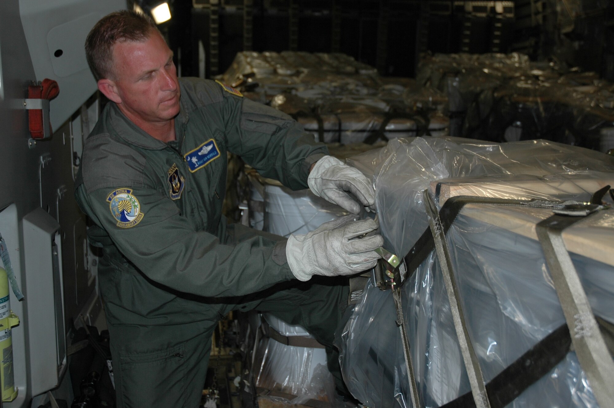 Master Sergeant Ron Newbold, loadmaster 315th Airlift Wing, secures a pallet of soybean seeds on a mission to Ramstein Air Force Base Germany, May 30. The seeds will be distributed to the farmers of Afghanistan to bring much needed nutrition to the region. (U.S. Air Force Photo/2nd Lt Joe Simms)