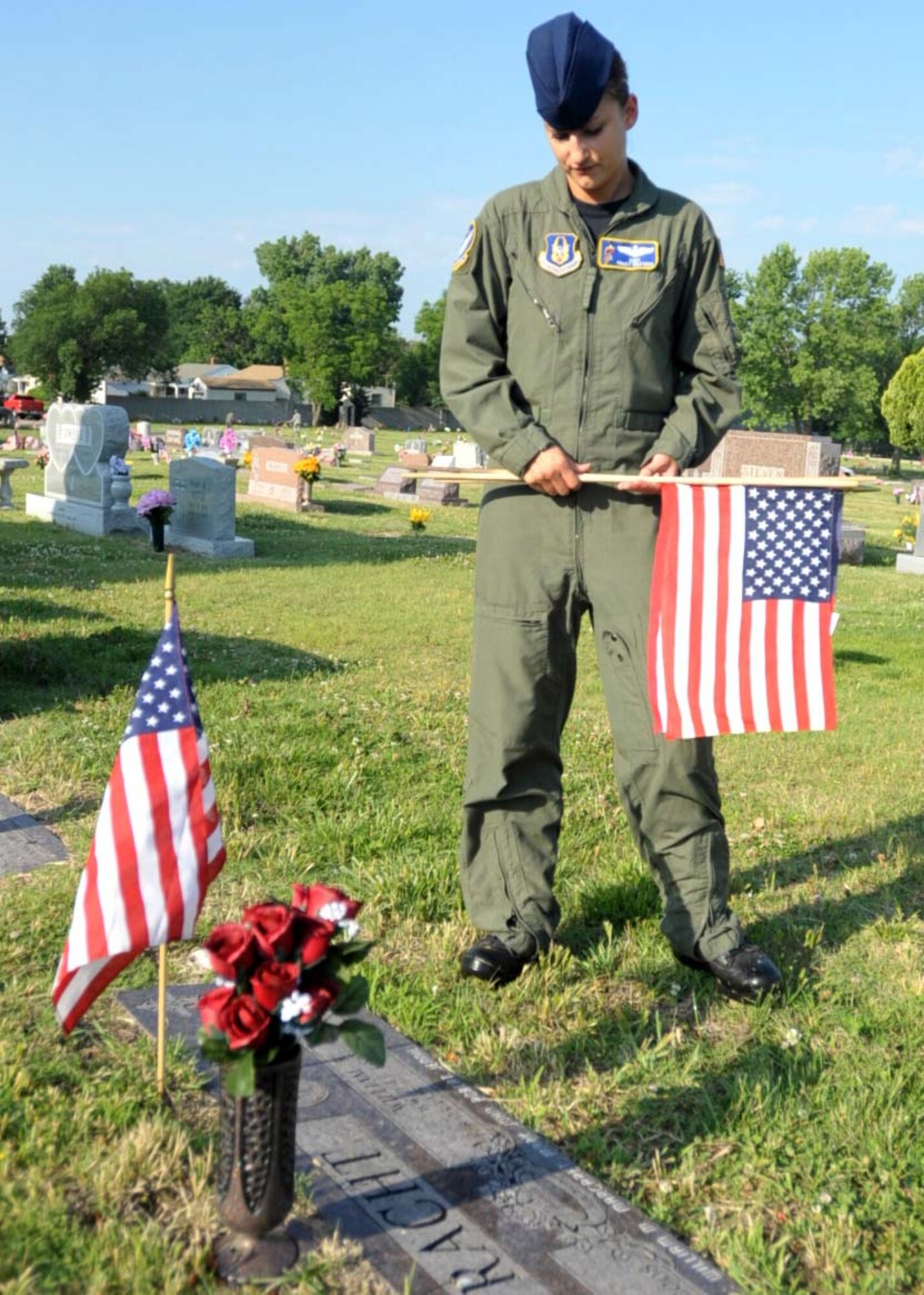 Staff Sgt. Tracy Castech, 18th Air Refueling Squadron, reads a headstone at Cavalary Cemetery after placing a small U.S. flag in honor of the veteran buried in the grave. Sergeant Castech and over 50 members of the 931st Air Refueling Group including their family members and other civic volunteers placed flags at two cemeteries in conjunction with Veterans of Foreign Wars Post 112 in Wichita, Kan. on May 29 in honor of Memorial Day. (Photo by Capt. Tim Wade/U.S. Air Force)