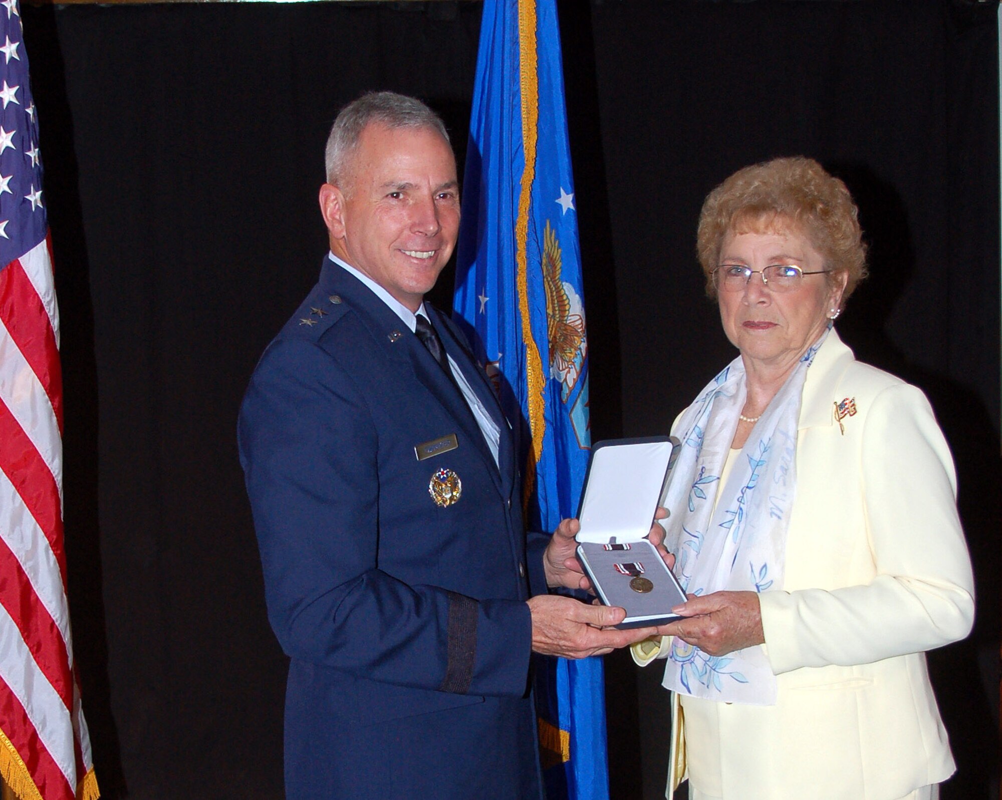 BARKSDALE AIR FORCE BASE, La. - Maj. Gen. Floyd Carpenter, 8th Air Force commander, presents the Prisoner of War Medal to Mildred Taylor-McKeithen during a ceremony honoring her late husband, Staff Sgt. James Taylor, at the 8th Air Force Museum on Barksdale Air Force Base May 21. Sergeant Taylor served as a B-17 waist gunner during World War II and was held prisoner by the Germans for eight months during the war. (U.S. Air Force photo/Maj. Richard Komurek)