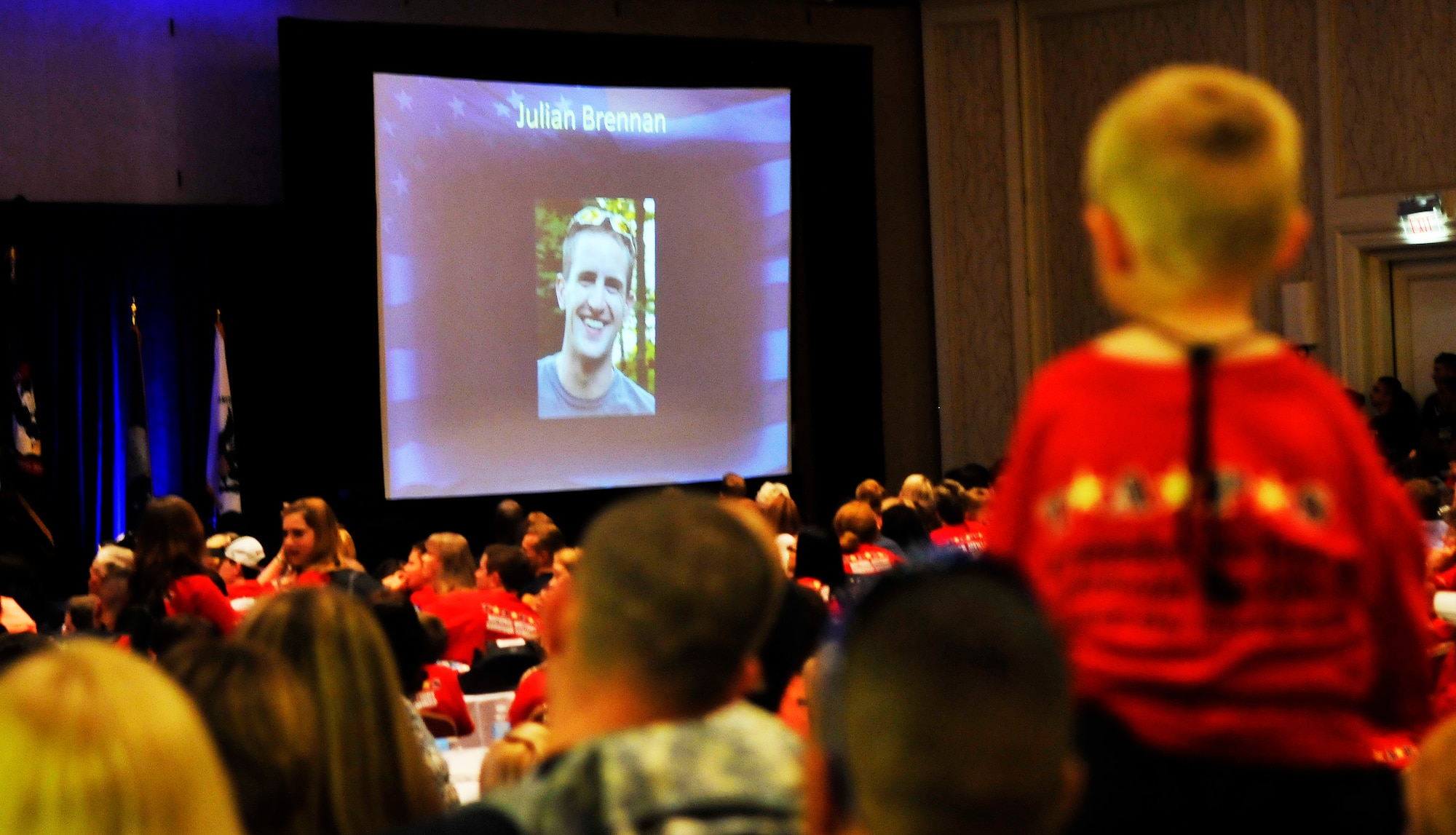 A young boy sits on the shoulders of his mentor to watch a slideshow honoring each of the attendees’ deceased loved ones during the 16th annual Tragedy Assistance Program for Survivors National Military Survivor Seminar and Good Grief Camp closing ceremony May 30. Since 1995, parents, spouses, siblings and other adults have attended the programs that incorporate a series of activities and workshops to help the attendees cope with the grief that comes with losing a loved one. (U.S. Air Force photo by Airman 1st Class Katherine Windish)