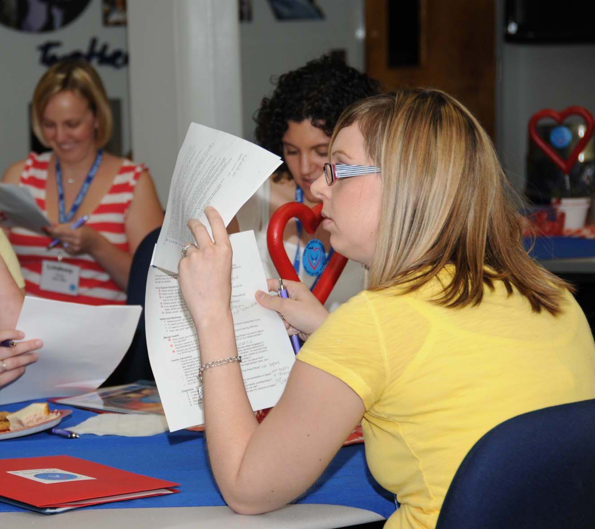 Aimee Hudson looks for a question to ask panel members from various base organizations during “What’s My Line?”, one of the group activities during Heart Link, May 27 at Sablich Center.  Her husband is Airman Zachary Hudson, a student in the 335th Training Squadron.  Heart Link, sponsored by the airman and family readiness center, helps spouses learn more about the Air Force mission, customs, traditions, protocol, resources and services.  (U.S. Air Force photo by Kemberly Groue)