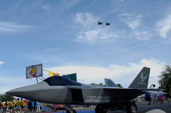 ALAMOGORDO, N.M. -- Framed by the Air Force Recruiting Station's mini-Raptor, two F-22 Raptors from the 49th Fighter Wing at Holloman Air Force Base fly over Washington Park as part of the opening ceremony for Alamogordo?s Armed Forces Day Celebration May 15, 2010. The pilots, Maj. Sason Camilletti and Capt. Andy Rule, are assigned to the 8th Fighter Squadron. (U.S. Air Force photo by Tom Fuller / Released)