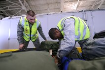 MINOT AIR FORCE BASE, N.D. -- Airmans 1st Class Alexander Mosher and Bruce Jones, 5th Logistics Readiness Squadron load team members, apply baggage tags to personal luggage during deployment preparation here May 27. Airmen from the 5th Bomb Wing are preparing to deploy to Andersen AFB, Guam, in support of U.S. Pacific Command’s continuous bomber presence in the Asia-Pacific region. (U.S. Air Force photo by Tech. Sgt. Lee A. Osberry, Jr.)