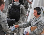 MINOT AIR FORCE BASE, N.D. -- Master Sgt. Christopher Pommier, 5th Logistics Readiness Squadron air terminal operations craftsman, takes boarding cards from 5th Bomb Wing personnel as they board a Boeing 767 here May 31. The 5th Bomb Wing is part of deployment rotation that provides U.S. Pacific Command with a continuous bomber presence in the Asia-Pacific region. (U.S. Air Force photo by Master Sgt. Michael Gaddis)
