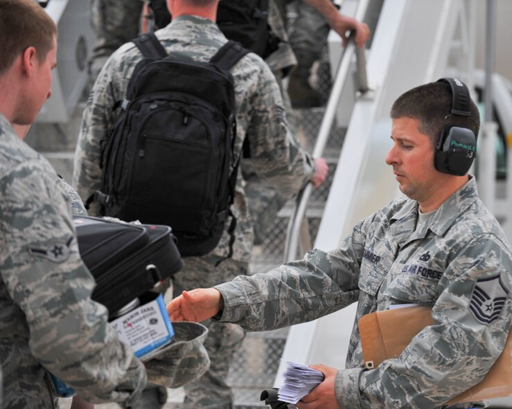 MINOT AIR FORCE BASE, N.D. -- Master Sgt. Christopher Pommier, 5th Logistics Readiness Squadron air terminal operations craftsman, takes boarding cards from 5th Bomb Wing personnel as they board a Boeing 767 here May 31. The 5th Bomb Wing is part of deployment rotation that provides U.S. Pacific Command with a continuous bomber presence in the Asia-Pacific region. (U.S. Air Force photo by Master Sgt. Michael Gaddis)