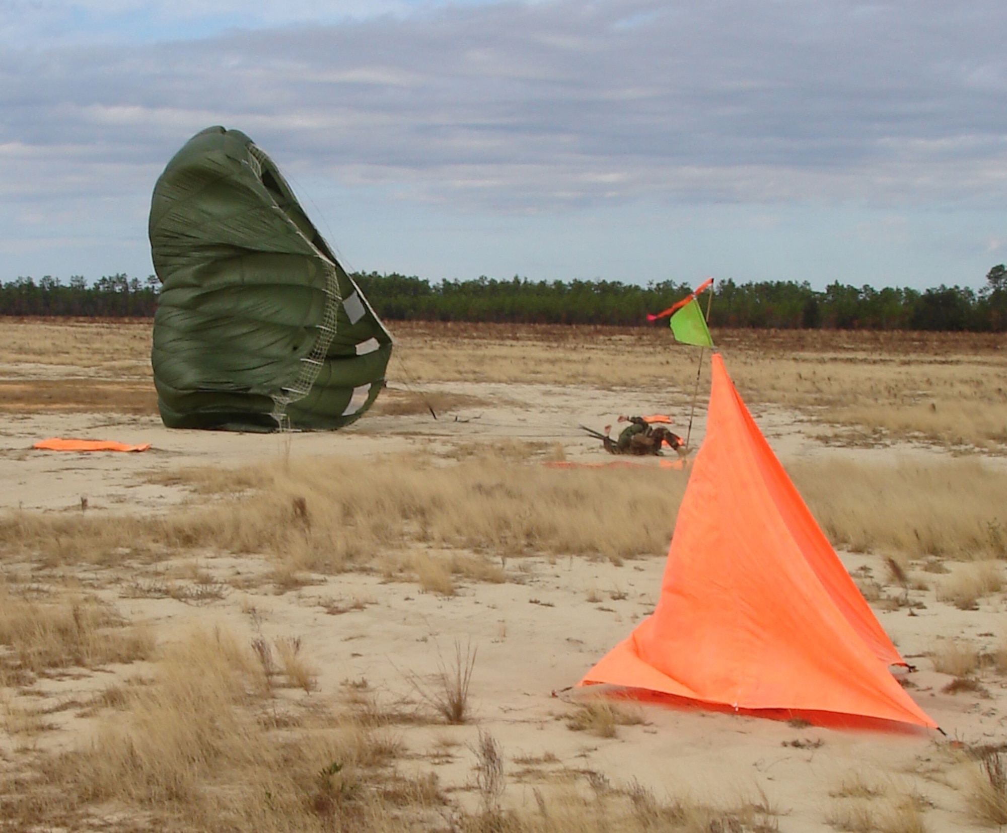 An unidentified parachutist lands next to the desired point of impact within the raised angle markers set by the 1st Special Operations Support Squadron Range Support flight Assault Zone team at an undisclosed location in the Eglin Range, Fla., Dec. 12, 2006. The Assault Zone team members draw on their combined experiences of more than 60 years in the field to assist Range Support clientele to successfully attain their Mission Essential Task Lists. (Courtesy photo)