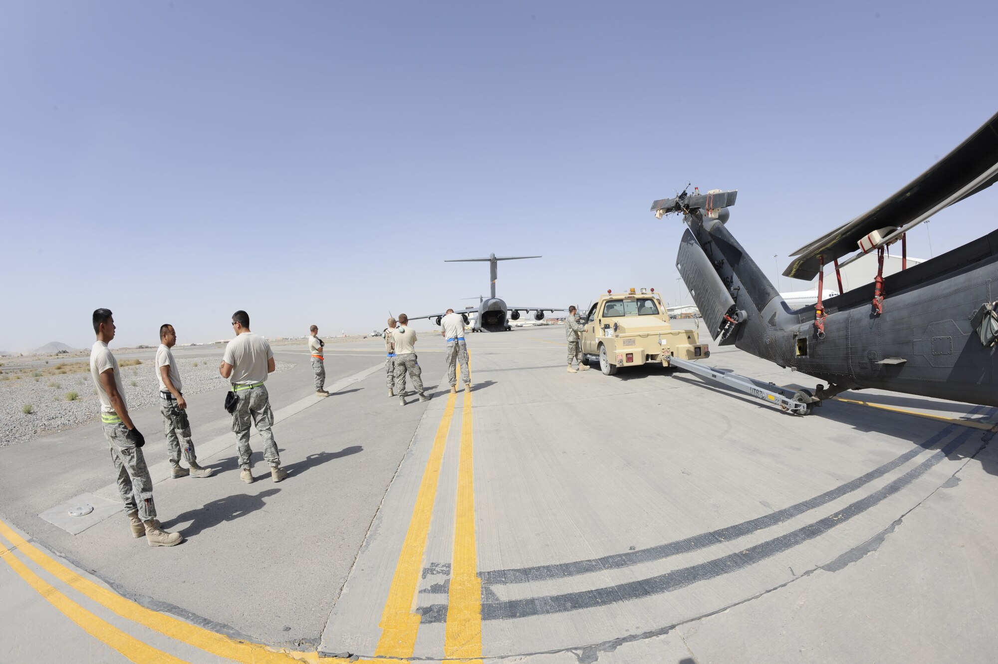 Airmen from the Helicopter Maintenance Unit wait to upload an HH-60G Pave Hawk onto a C-17 Globemaster III May 25 at Kandahar Airfield, Afghanistan.  The helicopter is being taken to another location for routine scheduled maintenance.  (U.S. Air Force photo by Senior Airman Nancy Hooks/Released)