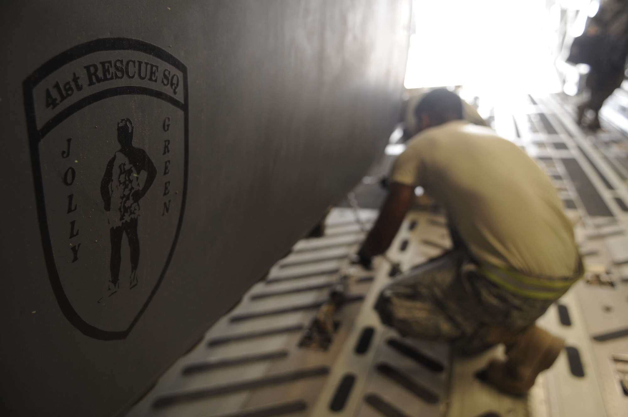 A folded HH-60G Pave Hawk is being tied down by the Helicopter Maintenance Unit May 25 after the helicopter was loaded onto a C-17 Globemaster III at Kandahar Airfield, Afghanistan.  Each small tie-down chain is rated at holding 10,000lbs and the larger tie-down chains gold 25,000lbs.  (U.S. Air Force photo by Senior Airman Nancy Hooks/Released)