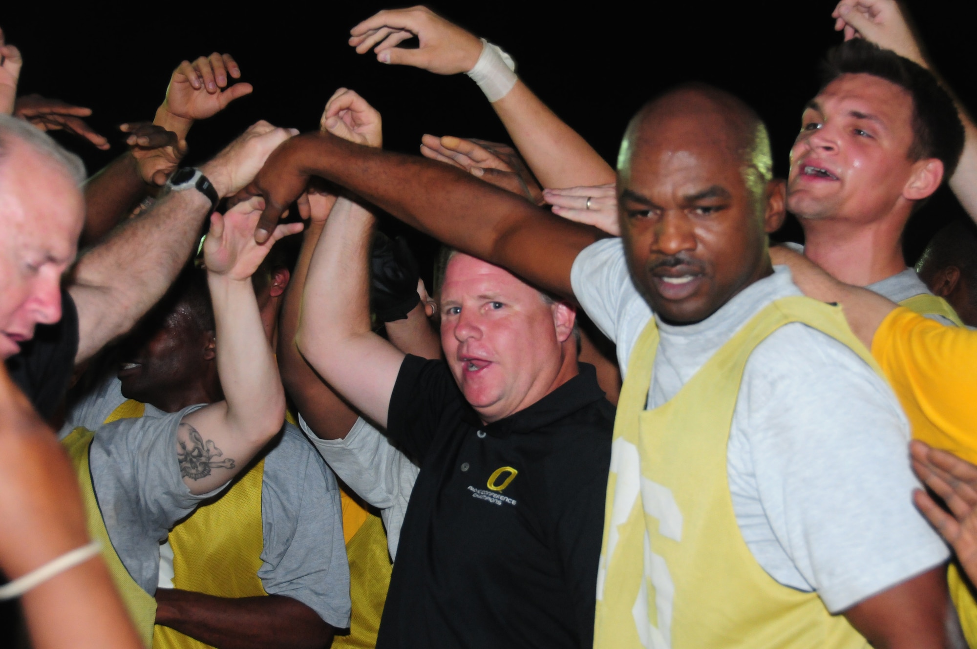 Chip Kelly, University of Oregon head football coach, celebrates a 12-8 Army Life Support Area victory over "The Rock" Air Force team here May 29, 2010 at an air base in Southwest Asia. Coach Kelly teamed up with Rich Ellerson, U.S. Military Academy head football coach, to guide the LSA team to its flag football win. (U.S. Air Force photo by Staff Sgt. Lakisha A. Croley/Released)