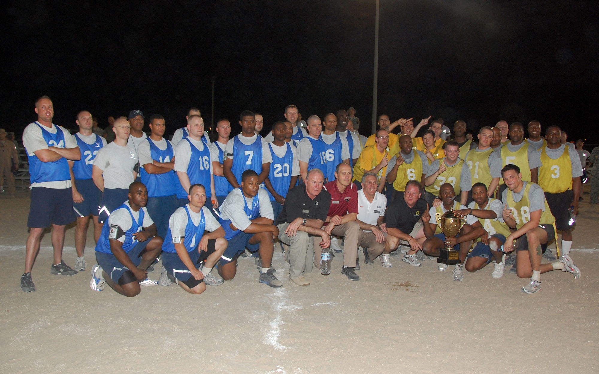 U.S. Air Force and Army members pose with college football coaches, from bottom center left, Rich Ellerson, Tim Murphy, Ron Zook and Chip Kelly after a flag football game May 29, 2010 at an undisclosed location in Southwest Asia. Coaches Ellerson and Kelly teamed up to coach the Life Support Area team, made up of mostly U.S. Army members, which defeated the U.S. Air Force team, led by coaches Murphy and Zook, 12-8 for the championship trophy and bragging rights. (U.S. Air Force photo by Tech. Sgt. Lindsey Maurice/Released)