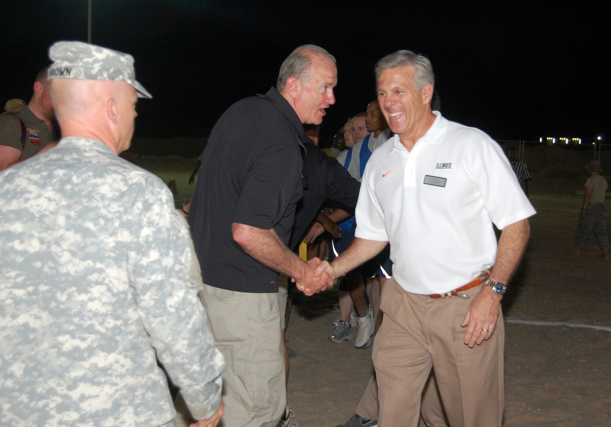 U.S. Military Academy head football coach Rich Ellerson shakes hands with University of Illinois head football coach Ron Zook after a flag football game May 29, 2010 at an air base in Southwest Asia. Coach Ellerson and University of Oregon head football coach Chip Kelly coached the winning Army Life Support Area team, edging them to a 12-8 victory over "The Rock" Air Force team. The coaches have been visiting military troops throughout the U.S. Central Command area or responsibility as part of a United Service Organization, Morale Entertainment Foundation and Under Armour-sponsored tour. (U.S. Air Force photo by Tech. Sgt. Lindsey Maurice/Released)