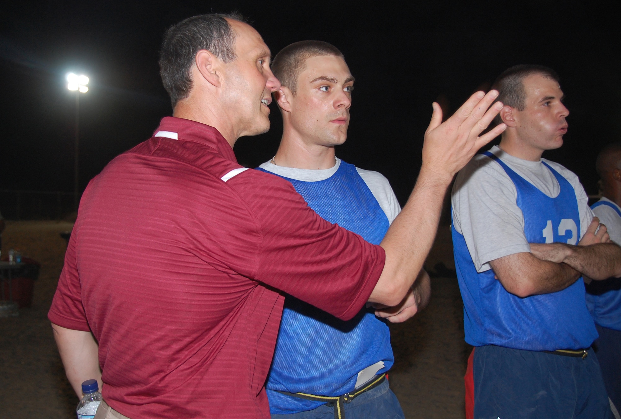Harvard head football coach Tim Murphy guides quarterback Staff Sgt. Chris Mavron of the 386th Expeditionary Contracting Squadron on his next offensive play during a flag football game May 29, 2010 at an air base in Southwest Asia. Coach Murphy visited the base along with three other college football coaches, as part of a United Service Organization, Morale Entertainment Foundation and Under Armour-sponsored tour through the U.S. Central Command area of responsibility. During the visit here, members of "The Rock" played a flag football game against the Army's Life Support Area, in which the college-level coaches split up to coach each team. (U.S. Air Force photo by Tech. Sgt. Lindsey Maurice/Released)