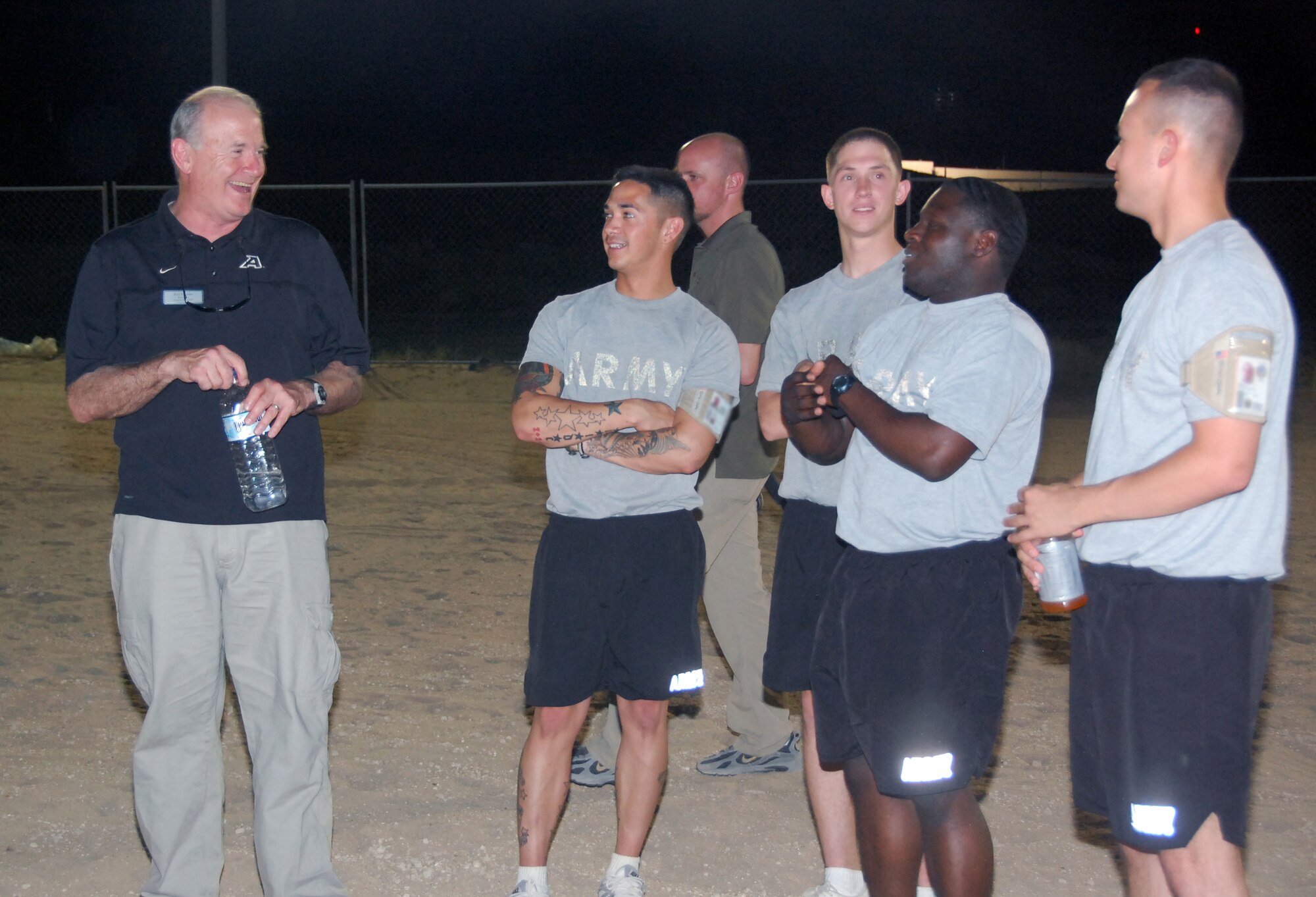 U.S. Military Academy head football coach Rich Ellerson talks with Soldiers during a flag football game May 29, 2010 at an air base in Southwest Asia. Coach Ellerson and three other college football coaches recently visited military members throughout the U.S. Central Command area of responsibility as part of a United Service Organization, Morale Entertainment Foundation and Under Armour-sponsored tour. (U.S. Air Force photo by Tech. Sgt. Lindsey Maurice/Released)