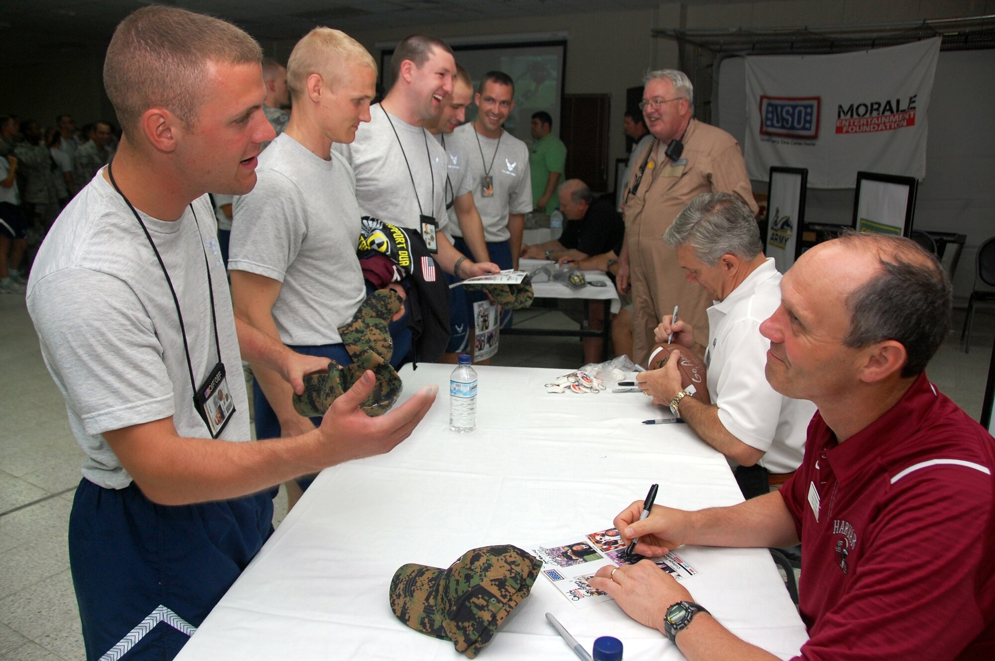 Tim Murphy, head football coach of Harvard University, and other college football coaches visit with Airmen of the 386th Air Expeditionary Wing here May 29, 2010 at an air base in Southwest Asia. The coaches signed autographs, coached a friendly game of flag football between the air base team and the Army's Life Support Area adjacent to the base, and ate breakfast with Airmen during their visit. (U.S. Air Force photo by Tech. Sgt. Lindsey Maurice/Released)