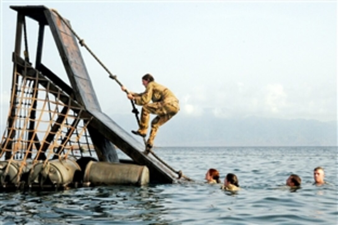 U.S. Navy midshipmen and U.S. Army cadets root for each other during the “individual rope climb” obstacle at the French Foreign Legion Nautical course in Djibouti, May 27, 2010. This was the first time females have ever gone through the course in Djibouti.