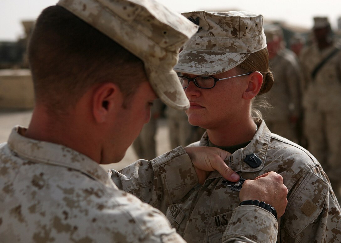 Petty Officer 3rd Class Amanda Jensen, a corpsman with Combat Logistics Battalion 6, 1st Marine Logistics Group (Forward), receives her Fleet Marine Force Warfare Specialist pin during a brief ceremony here June 2. Jensen, a native of Lima, Mont., received her Fleet Marine Force qualification along with two fellow Corpsmen within the battalion and spent several months preparing for the testing process. To receive the qualification, sailors must display general Marine Corps knowledge demonstrate their understanding in everything from unit organization, mission and equipment and must pass a series of written, oral and hands-on examinations.