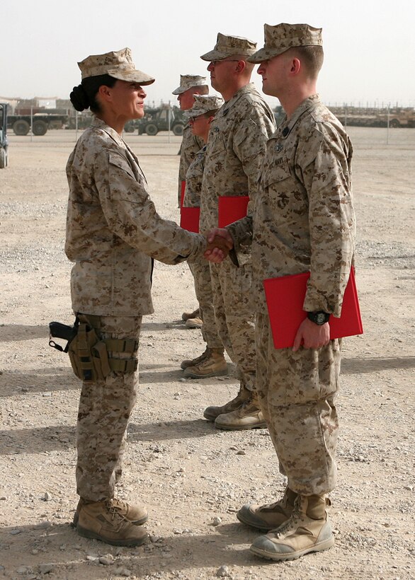 Seaman Nathaniel Novak, a corpsman with Combat Logistics Battalion 6, 1st Marine Logistics Group (Forward), receives a congratulatory handshake from 1st Sgt. Raquel Painter, company first sergeant, Headquarters and Support Company, CLB-6, 1st MLG (FWD) during a brief ceremony here, June 2. Novak, a native of Brooklyn, Mich., received his Fleet Marine Force qualification along with two fellow corpsmen within the battalion and spent several months preparing for the testing process. To receive the qualification, sailors must display general Marine Corps knowledge and demonstrate their understanding in everything from unit organization, mission and equipment and must pass a series of written, oral and hands-on examinations.