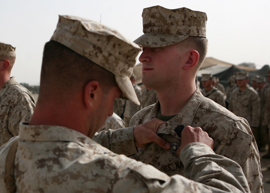 Seaman Nathaniel Novak, a corpsman with Combat Logistics Battalion 6, 1st Marine Logistics Group (Forward), receives his Fleet Marine Force Warfare Specialist pin during a brief ceremony here June 2. Novak, a native of Brooklyn, Mich., received his Fleet Marine Force qualification along with two fellow Corpsmen within the battalion and spent several months preparing for the testing process. To receive the qualification, sailors must display general Marine Corps knowledge demonstrate their understanding in everything from unit organization, mission and equipment and must pass a series of written, oral and hands-on examinations.