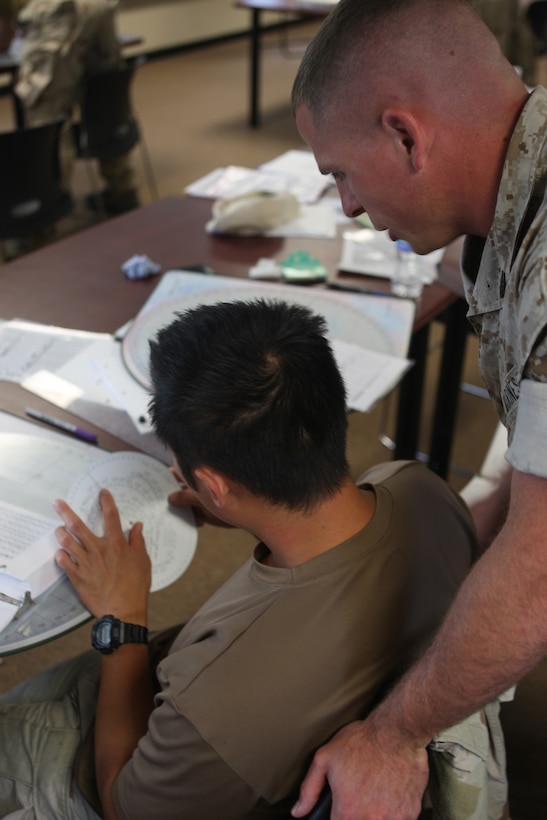 Staff Sgt. Christopher Balance, combat instructor with the Advanced Infantry Training Battalion, Camp Geiger, instructs a Navy SEAL from the Joint Expeditionary Base Little Creek – Fort Story, Va., on calculating various target points on a mortar plotting board during an Infantry Mortars Leader Course, recently. The SEAL unit’s visit was in order to learn the mortar system and operations for themselves in the event they needed indirect fire support while deployed to a combat zone.