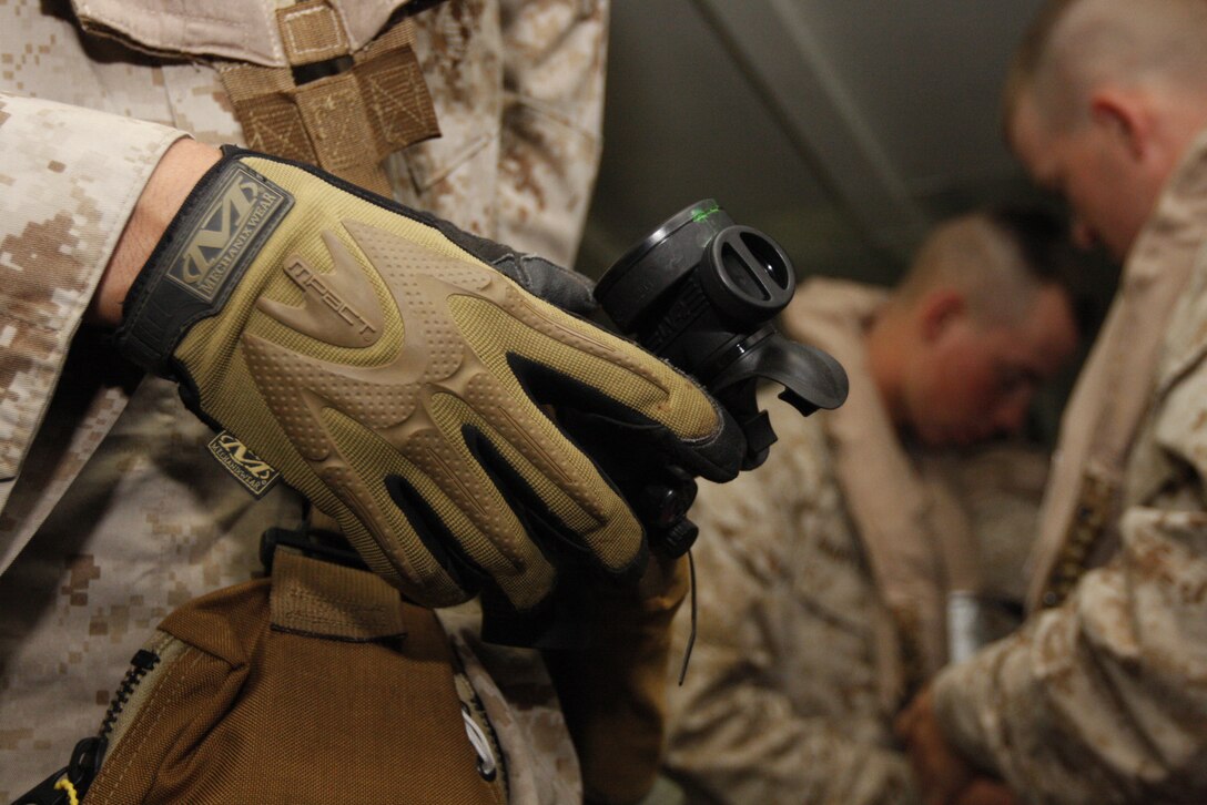 Lance Cpl. Aaron Denson, a rifleman with Company C, Battalion Landing Team 1st Battalion, 7th Marine Regiment, adjusts his air tank before boarding a CH-46 Sea Knight Helicopter June 4 aboard the USS Bonhomme Richard. The BLT used the exercise to train for a deployment with the 31st Marine Expeditionary Unit next month.
