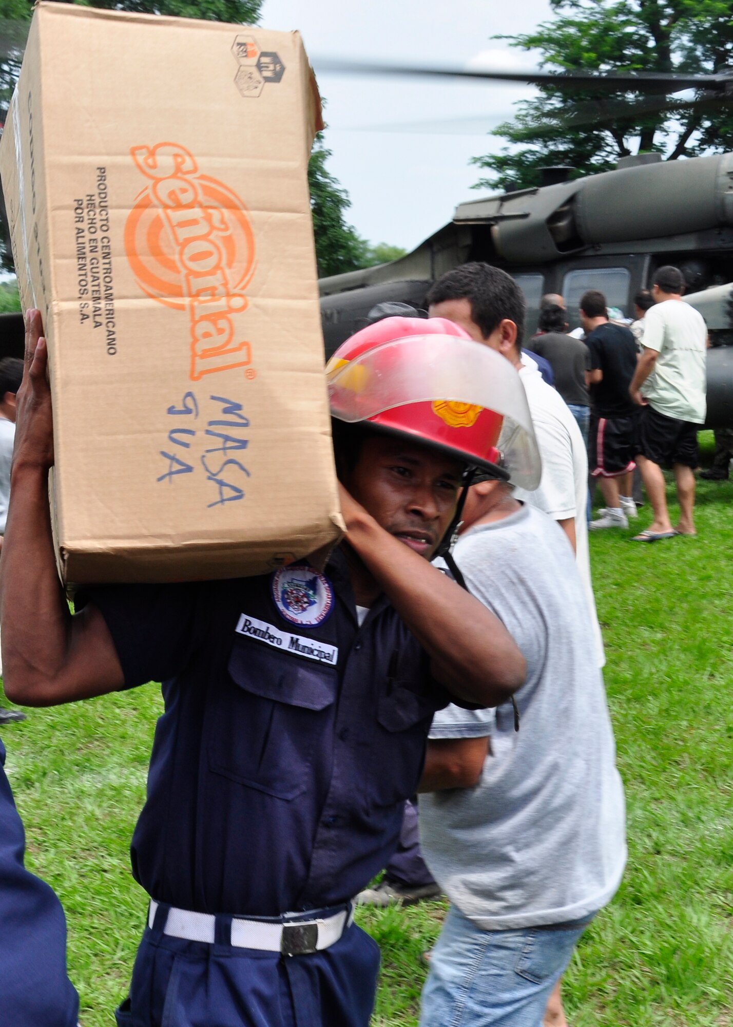 A firefighter from the community of Masagua, Guatemala carries supplies from a Joint Task Force-Bravo UH-60 Blackhawk June 3. Joint Task Force-Bravo deployed four helicopters, at the request of the Guatemalan government, to support disaster relief efforts following the Pacaya Volcano eruption and Tropical Storm Agatha. Joint Task Force-Bravo’s helicopters and personnel have helped transport more than 40,000 lbs. of relief supplies to six Guatemalan communities in need. (U.S. Air Force photo by Staff Sgt. Bryan Franks)