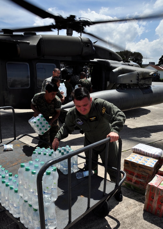 Guatemalan military personnel and Joint Task Force-Bravo members load a UH-60 Blackhawk with food and water June 3 to provide disaster relief in rural communities of Guatemala affected by Tropical Storm Agatha. Joint Task Force-Bravo’s helicopters and personnel helped transport more than 40,000 lbs. of relief supplies to six communities in need. (U.S. Air Force photo by Staff Sgt. Bryan Franks)