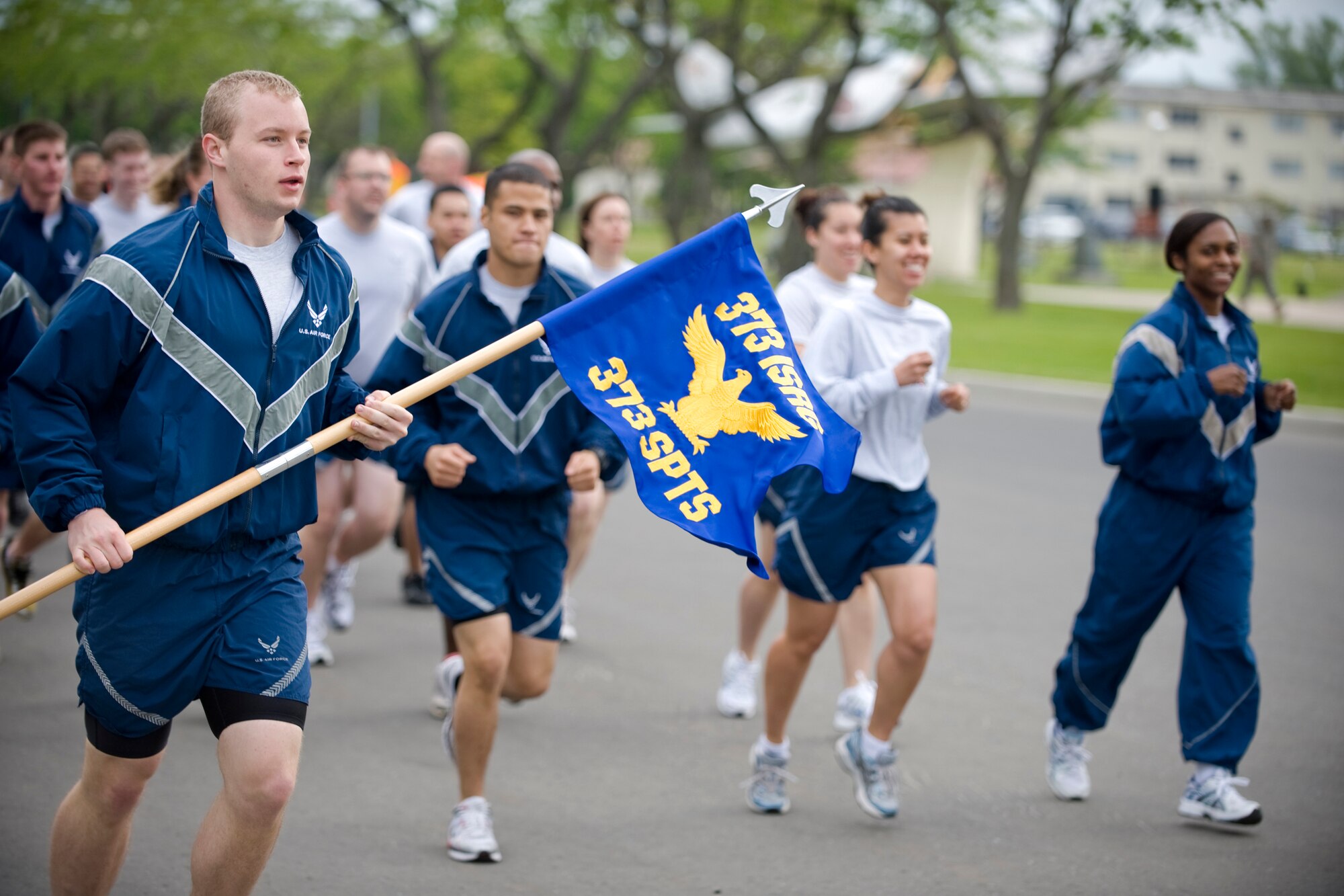 MISAWA AIR BASE, Japan -- Airman 1st Class Ernest Heinrich, 373rd Support Squadron conventional-systems technician, bears the guidon as he leads his squadron during a readiness run June 4 at Risner Circle. Readiness runs encourage fitness and boost morale throughout participating units. (U.S. Air Force photo/Senior Airman Jamal D. Sutter)