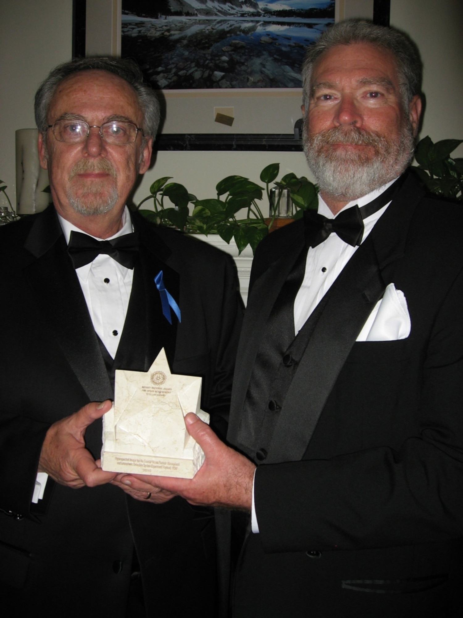 David Hess, director of the DoD Space Test Program’s Human Space Flight Payloads Office, and Dr. Perry Ballard, payload manager for the DoD Space Test Program, accept a team award for the development of the Hyperspectral Imager for the Coastal Ocean Remote Atmospheric and Ionospheric Detection System. The Information gleaned from the imager, can spot navigational hazards, unusual sea floor characteristics, water properties and underwater terrain. (Courtesy photo)