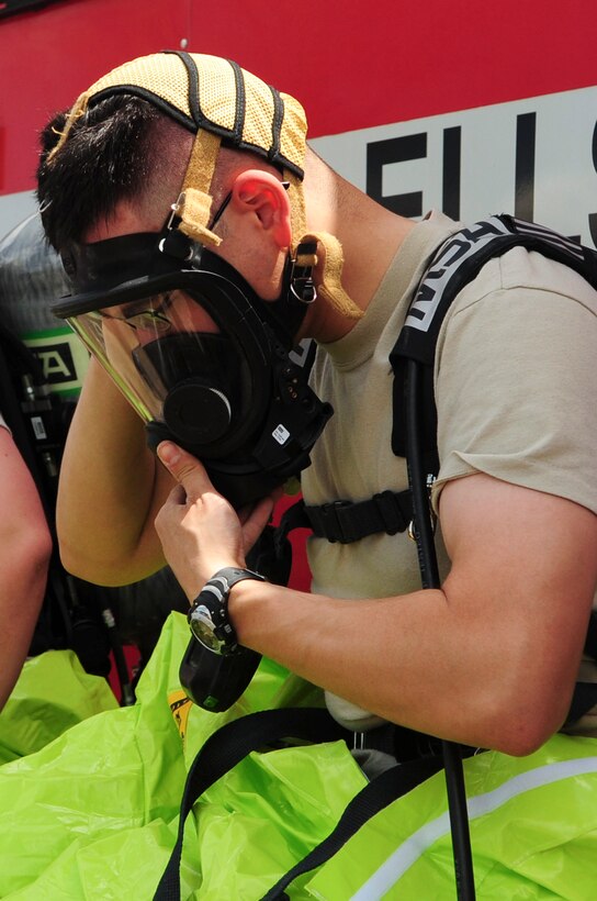 ELLSWORTH AIR FORCE BASE S.D. - Airman 1st Class Matthew Hung, 28th Civil Engineer Squadron emergency management journeyman, adjusts his gas mask before participating in an emergency management exercise, June 3.  Members from the emergency management section and 28th Medical Group bioenvironmental section combined to perform various scenarios involving chemical, biological, radiological and nuclear detection and decontamination operations. (U.S. Air Force photo/Airman 1st Class Corey Hook)