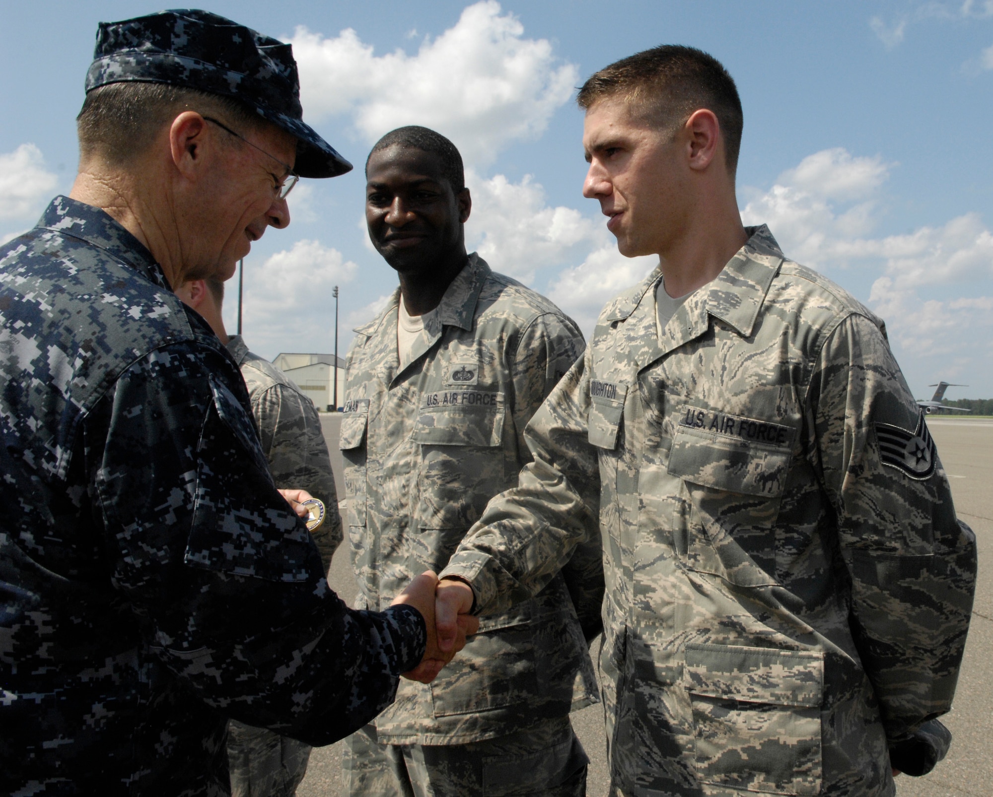U.S. Navy Adm. Mike Mullen coins Staff Sgt. Jonathan Houghton after an all-hands call at the base theater on Joint Base Charleston, S.C., June 3, 2010. During his visit, Admiral Mullen fielded questions from officers and enlisted Airmen and addressed Department of Defense policy changes and expectations. Questions asked ranged from concerns with manning to the removal of fast food in deployed locations. Admiral Mullen is the Chairman of the Joint Chiefs of Staff and Sergeant Houghton is a protocol specialist with the 628th Air Base Wing. (U.S. Air Force Photo/Airman 1st Class Lauren Main)
