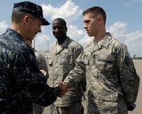 U.S. Navy Adm. Mike Mullen coins Staff Sgt. Jonathan Houghton after an all-hands call at the base theater on Joint Base Charleston, S.C., June 3, 2010. During his visit, Admiral Mullen fielded questions from officers and enlisted Airmen and addressed Department of Defense policy changes and expectations. Questions asked ranged from concerns with manning to the removal of fast food in deployed locations. Admiral Mullen is the Chairman of the Joint Chiefs of Staff and Sergeant Houghton is a protocol specialist with the 628th Air Base Wing. (U.S. Air Force Photo/Airman 1st Class Lauren Main)