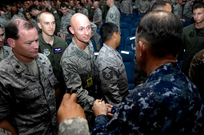 U.S. Navy Adm. Mike Mullen coins a Staff Sgt. Darren Ellis after an all-hands call at the base theater on Joint Base Charleston, S.C., June 3, 2010. During his visit, Admiral Mullen fielded questions from officers and enlisted Airmen and addressed Department of Defense policy changes and expectations. Questions asked ranged from concerns with manning to the removal of fast food in deployed locations. Admiral Mullen is the Chairman of the Joint Chiefs of Staff and Sergeant Ellis is with the 315th Airlift Wing Public Affairs Office. (U.S. Air Force Photo/Airman 1st Class Lauren Main)
