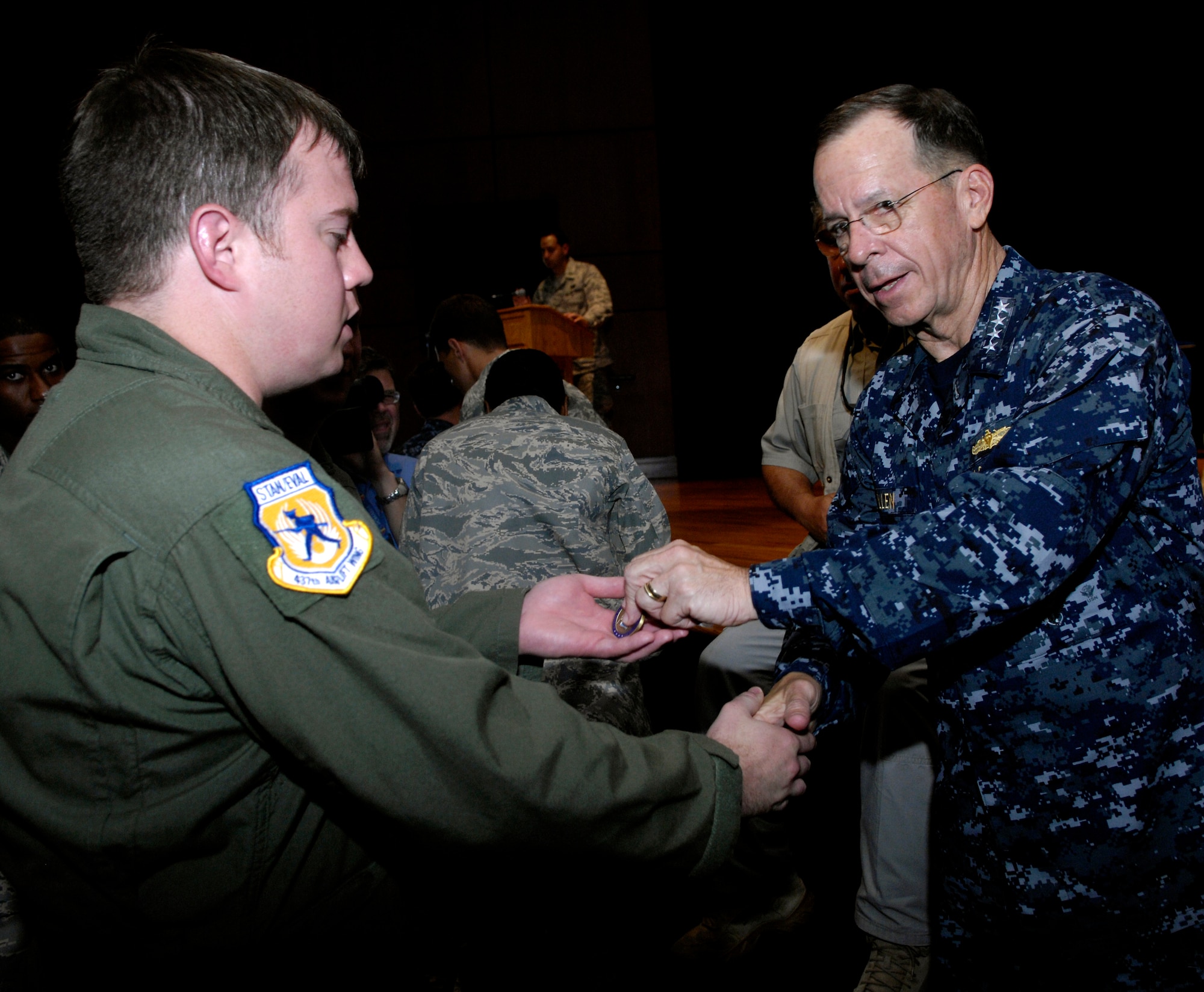 U.S. Navy Adm. Mike Mullen coins an Airman after an all-hands call at the base theater on Joint Base Charleston, S.C., June 3, 2010. During his visit, Admiral Mullen fielded questions from officers and enlisted Airmen and addressed Department of Defense policy changes and expectations. Questions asked ranged from concerns with manning to the removal of fast food in deployed locations. Admiral Mullen is the Chairman of the Joint Chiefs of Staff. (U.S. Air Force Photo/Airman 1st Class Lauren Main)
