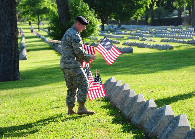 Members of the914th Security Forces place American flags on graves during a Memorial Day ceremony May 31, 2010, Forest Lawn Cemetery Buffalo NY. During the morning thousands of flags where placed next to those men and woman who died while serving the United States military. (U.S. Air Force photo by Staff Sgt. Joseph McKee)