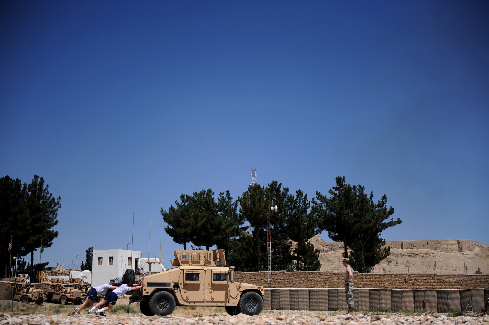 Airman assigned to the Provincial Reconstruction Team Zabul push a Humvee so a bottle tied to the front bumper gets within a taped box on the cement, at one of the stations for the team's morale day, ''Amazing Race,'' competition May 29, 2010, Forward Operating Base Smart, Afghanistan. The competition, which featured 11 four-person teams, featured sharp shooting, horseshoes, a Humvee push, a bottle cap match game, brain teasers, push-ups and lots of cardio. (U.S. Air Force photo/Staff Sgt. Manuel J. Martinez/released) 

