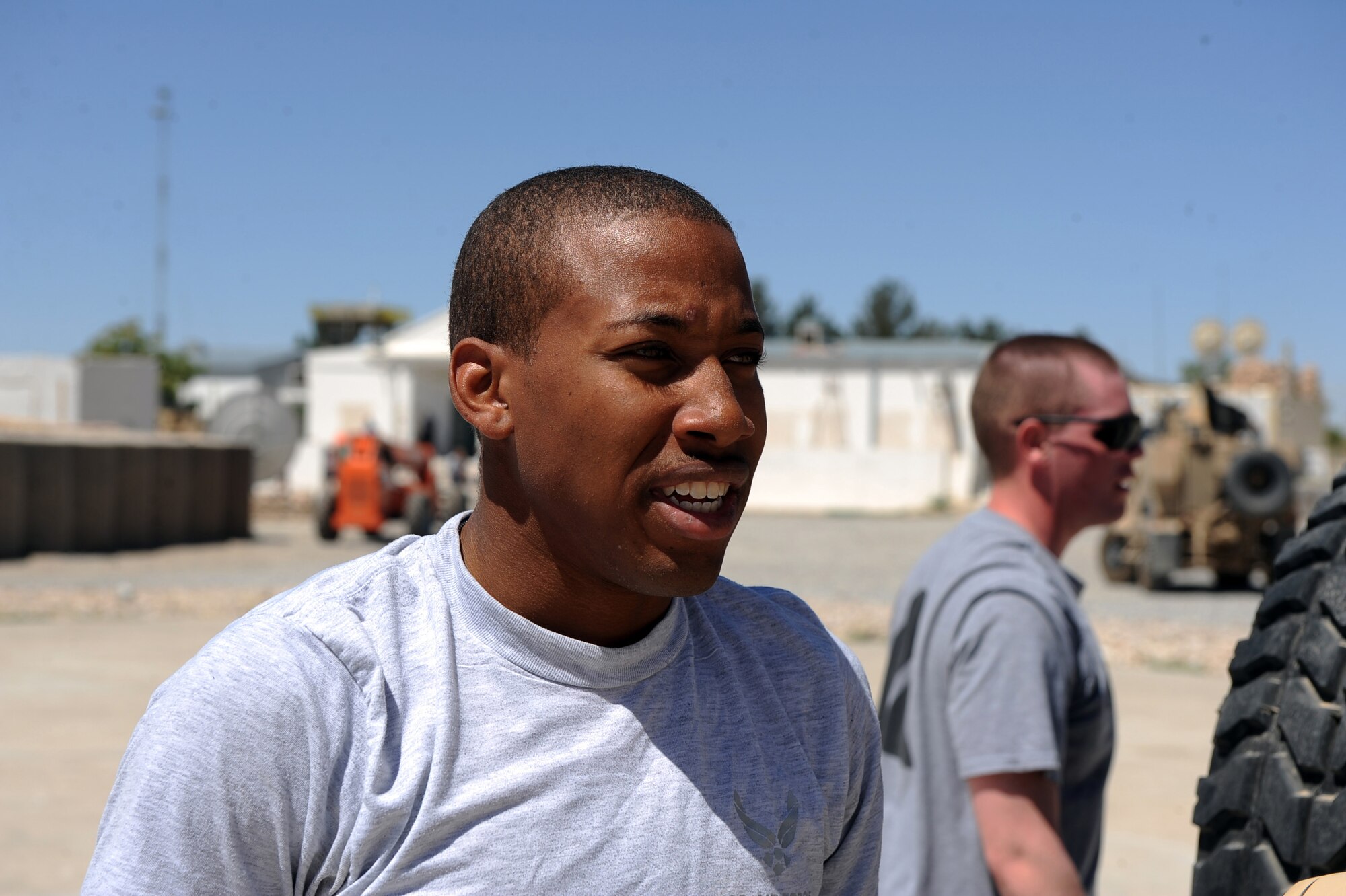 Senior Airman Xavier Baker, communications specialist assigned to the Provincial Reconstruction Team Zabul, takes a breather after helping his team push a Humvee until a water bottle tied to the bumper of the vehicle is within a taped box on the ground, during the team's morale day, ''Amazing Race,'' competition May 29, 2010, at Forward Operating Base Smart, Afghanistan. ?Man when I was pushing that Humvee, I was tired,? Airman Baker said. (U.S. Air Force photo/Staff Sgt. Manuel J. Martinez/released) 