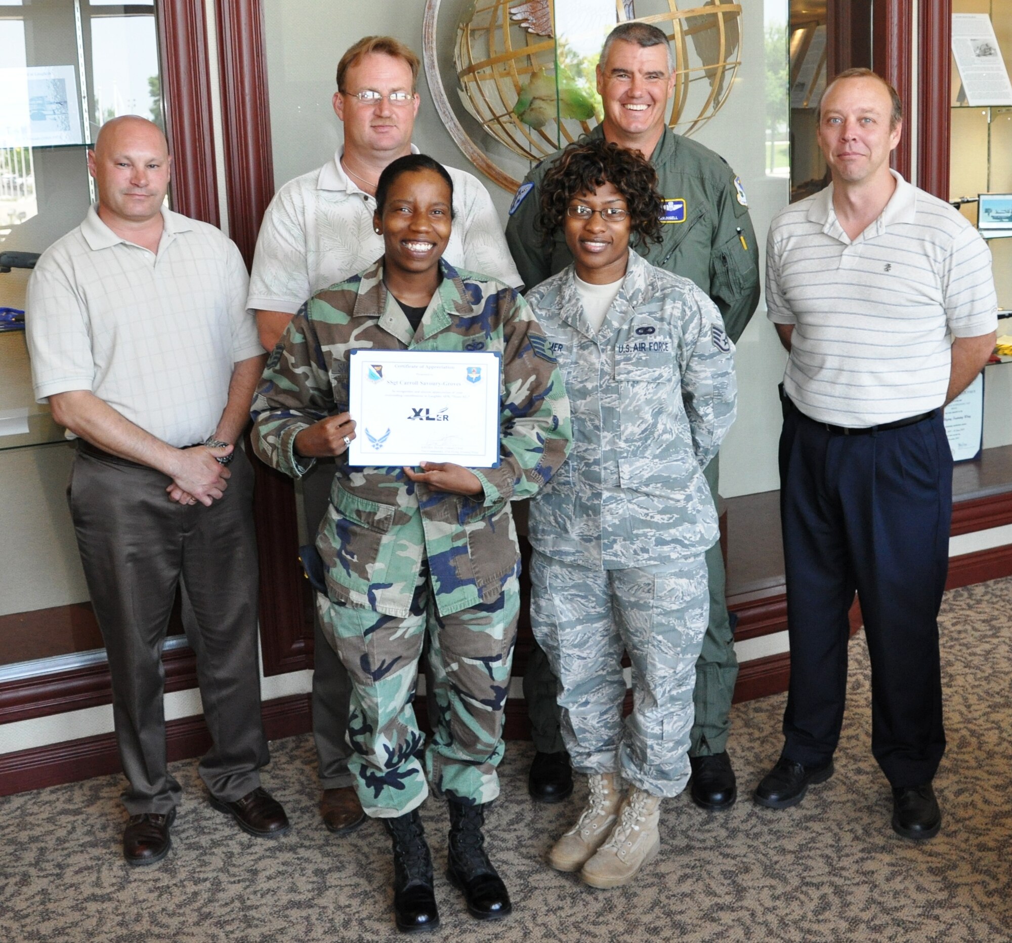 LAUGHLIN AIR FORCE BASE, Texas – Staff Sgt. Carroll Savoury-Groves, 47th Flying Training Wing Information Protection, poses with fellow members of her squadron after being presented the XLer of the Week award by Col. David Ellis, 47th Flying Training Wing vice commander, June 2. The XLer is a weekly award given to individuals who consistently make outstanding contributions to Laughlin and their unit. (U.S. Air Force photo by Airman 1st Class Blake Mize)