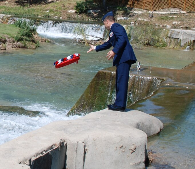 LAUGHLIN AIR FORCE BASE, Texas – Maj. Shannon Hoefferle, 47th Comptroller Squadron commander, tosses a wreath into the San Felipe Creek in Del Rio during a Memorial Day ceremony May 31. Representatives of the Air Force, Army, Navy, Marine Corps and Coast Guard participated in the event. (U.S. Air Force photo by Joel Langton) 