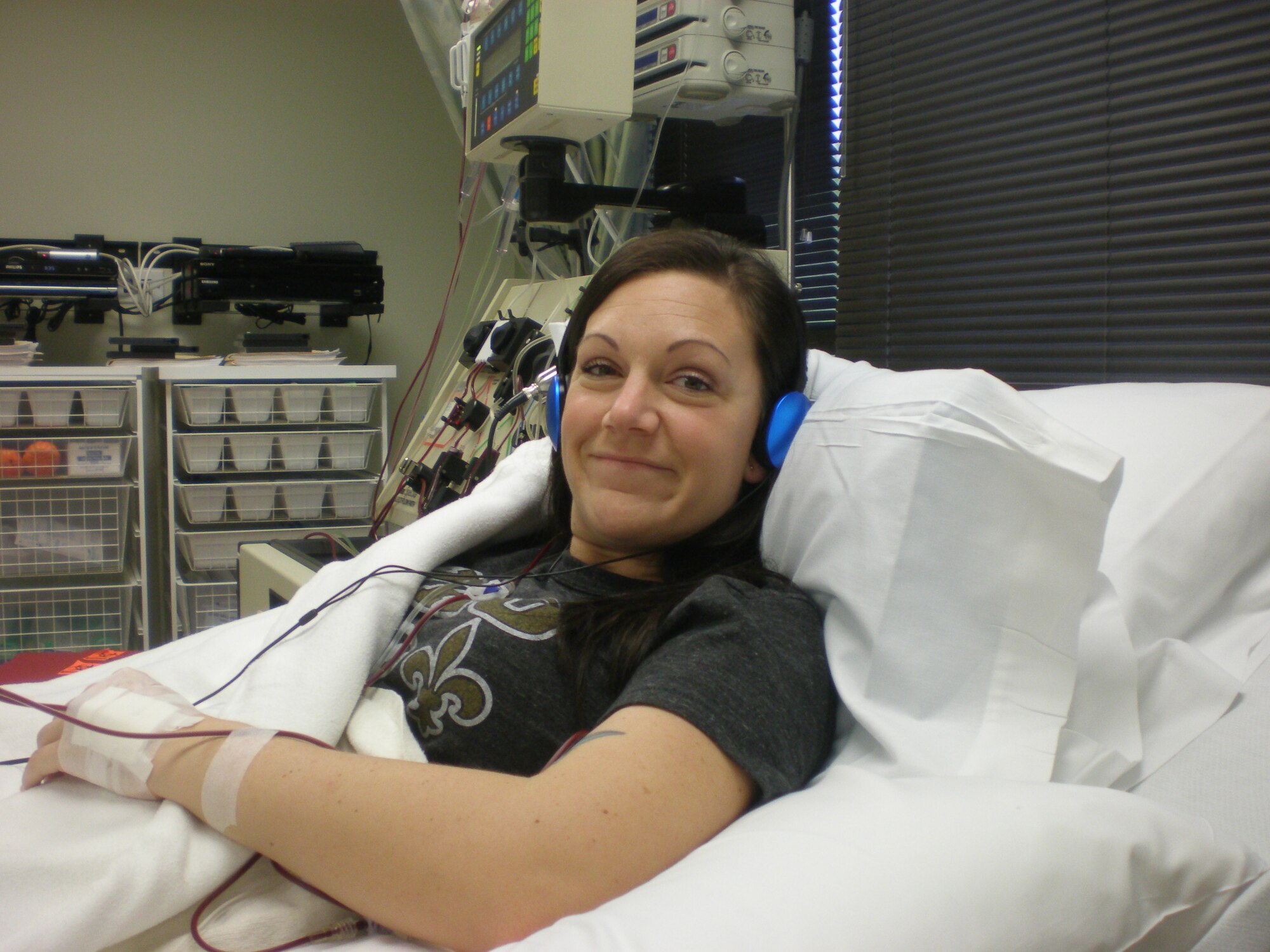 Staff Sgt. Alexis King, 48th Fighter Wing command post emergency actions controller, lays in a hospital bed, in Washington D.C., while her blood travels through a blood cell separator machine collecting stem cells April 23.  The process is called apheresis, where a needle is placed into each of my arms.  Blood is removed from a vein in one arm and passed through tubing into the machine and then back into her other vein.  This was the 5th day in the process of donating bone marrow.(Courtesy photo)