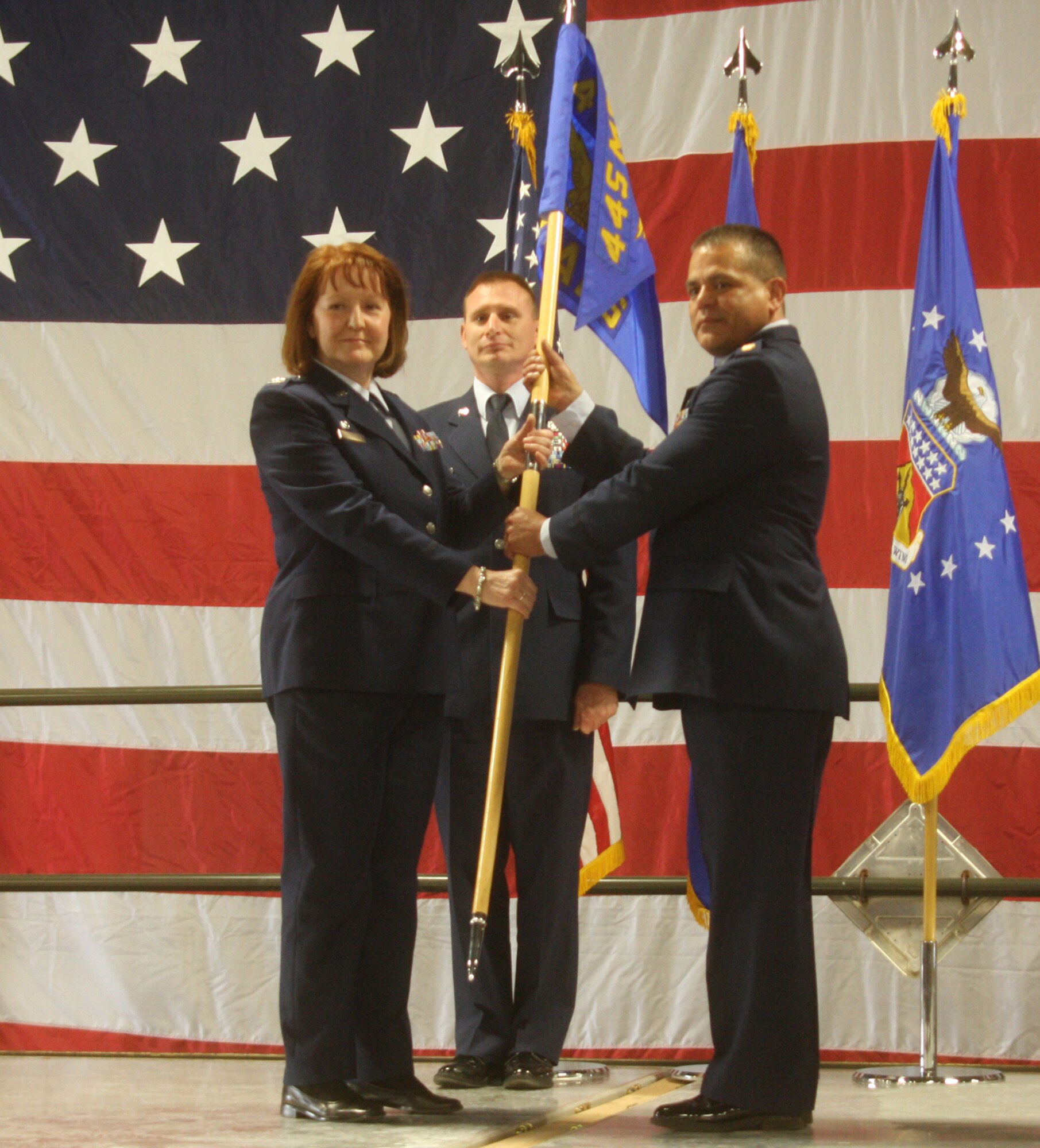 WRIGHT-PATTERSON AIR FORCE BASE, Ohio – Col. Mary Henderhan, 445th Mission Support Group commander, passes the guidon to Maj. John Marang, incoming 87th Aerial Port Squadron commander, as Senior Master Sgt. Michael Brimmer looks on during the May 16 change of command ceremony.  Maj. David Mohr relinquished command of the 87 APS to Major Marang after serving in the position since October of 2008.  Major Marang was previously assigned as the officer in charge of air freight operations, 87 APS. (U.S. Air Force photo/Senior Airman Mikhail Berlin)