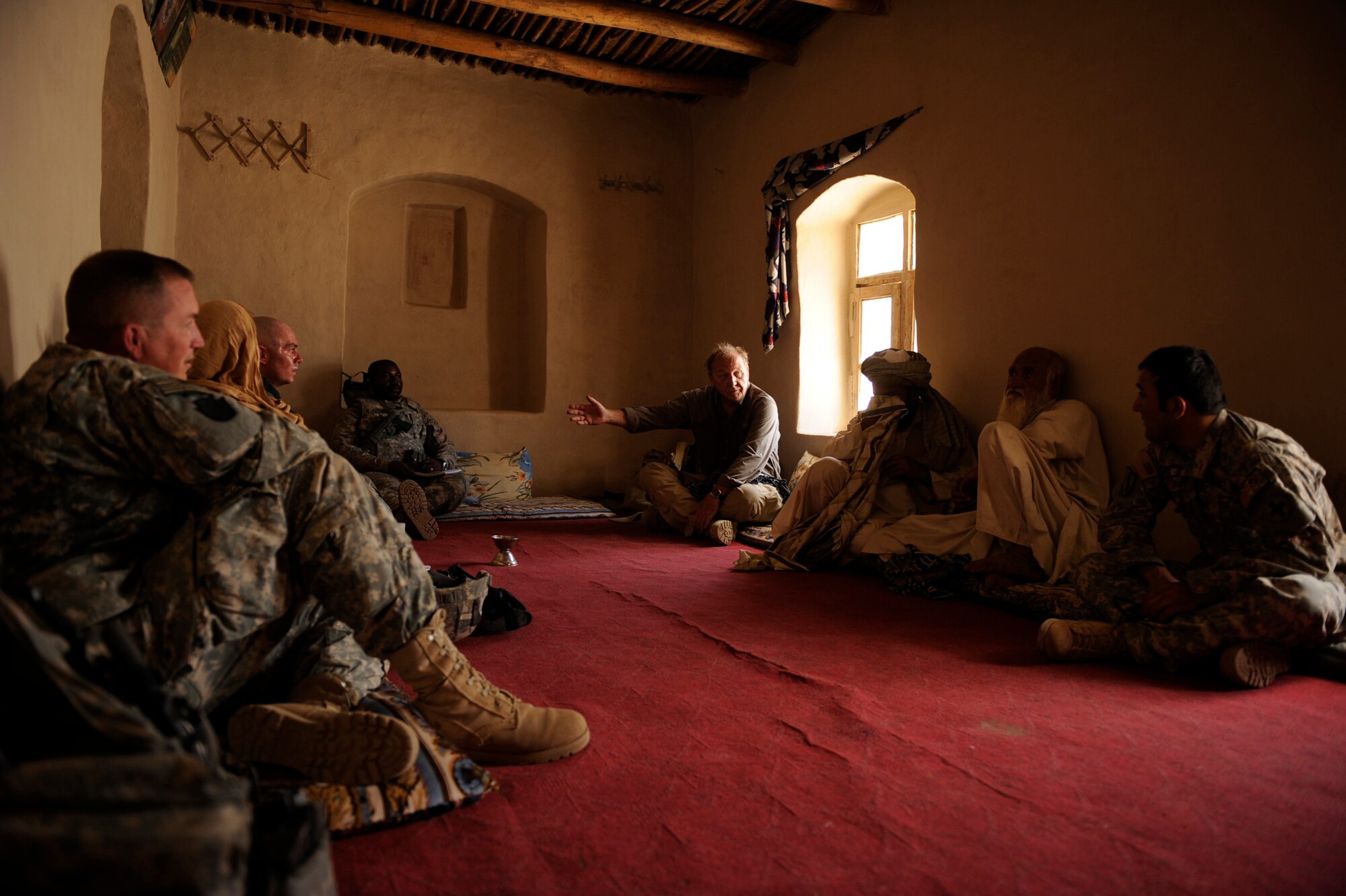 Dr. Jim Helton, U.S. Agency for International Development field program officer, working with Provincial Reconstruction Team Zabul, speaks with the Khalqdad Khan village elder during a meeting in the elder's home May 24, 2010, in Khaleqdad Khan, Afghanistan. ?As PRT Soldiers and Airmen funnel in and out they add to the reconstructive development and sustainability we build as a team," Dr. Helton said. "When we share the same vision and are well-integrated we are able to serve the people of Zabul as on single-minded unit focused on serving the Afghan people here.? (U.S. Air Force photo/Staff Sgt. Manuel J. Martinez/released) 