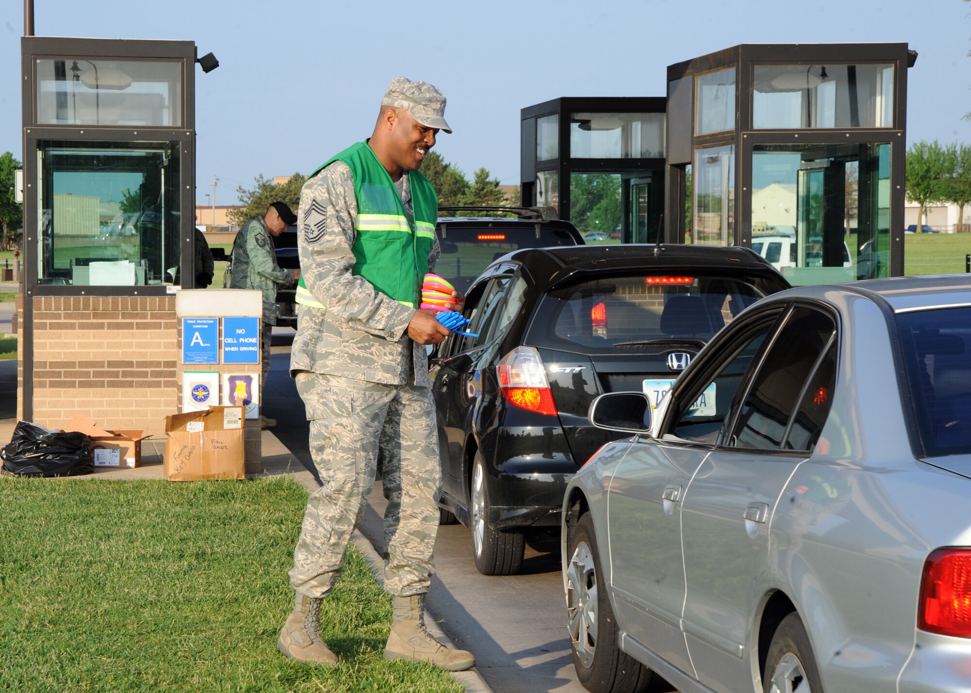 Chief Master Sgt. Boyd Bryant, 22nd Force Support Squadron superintendent, greets a driver entering the main gate with a frisbee and a safety message May 27, 2010, McConnell Air Force Base, Kan. Members of leadership were posted at the gate to help remind Team McConnell members to be safe during the Memorial Day weekend. The 2010 campaign kicked off the 2010 Critical Days of Summer program Air Force-wide May 28. (U.S. Air Force photo/Airman 1st Class Andrea Salazar)