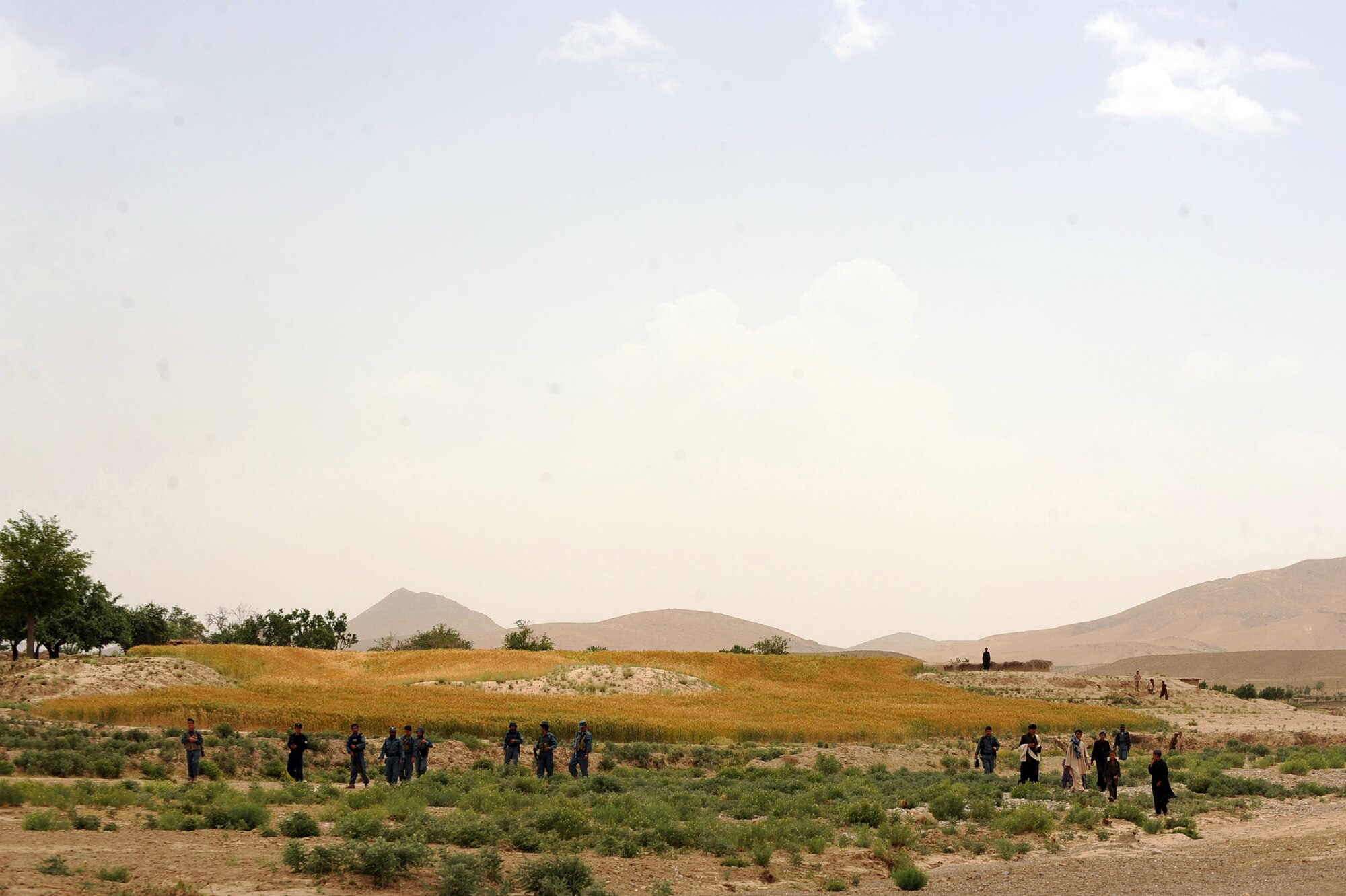 Afghan National Police and Afghan civilians wait for Airmen and Soldiers assigned to Provincial Reconstruction Team Zabul,  to arrive at a village for a Shura meeting in the Omarkhel village May 22, 2010,in Zabul Province, Afghanistan. (U.S. Air Force photo/Staff Sgt. Manuel J. Martinez/released) 