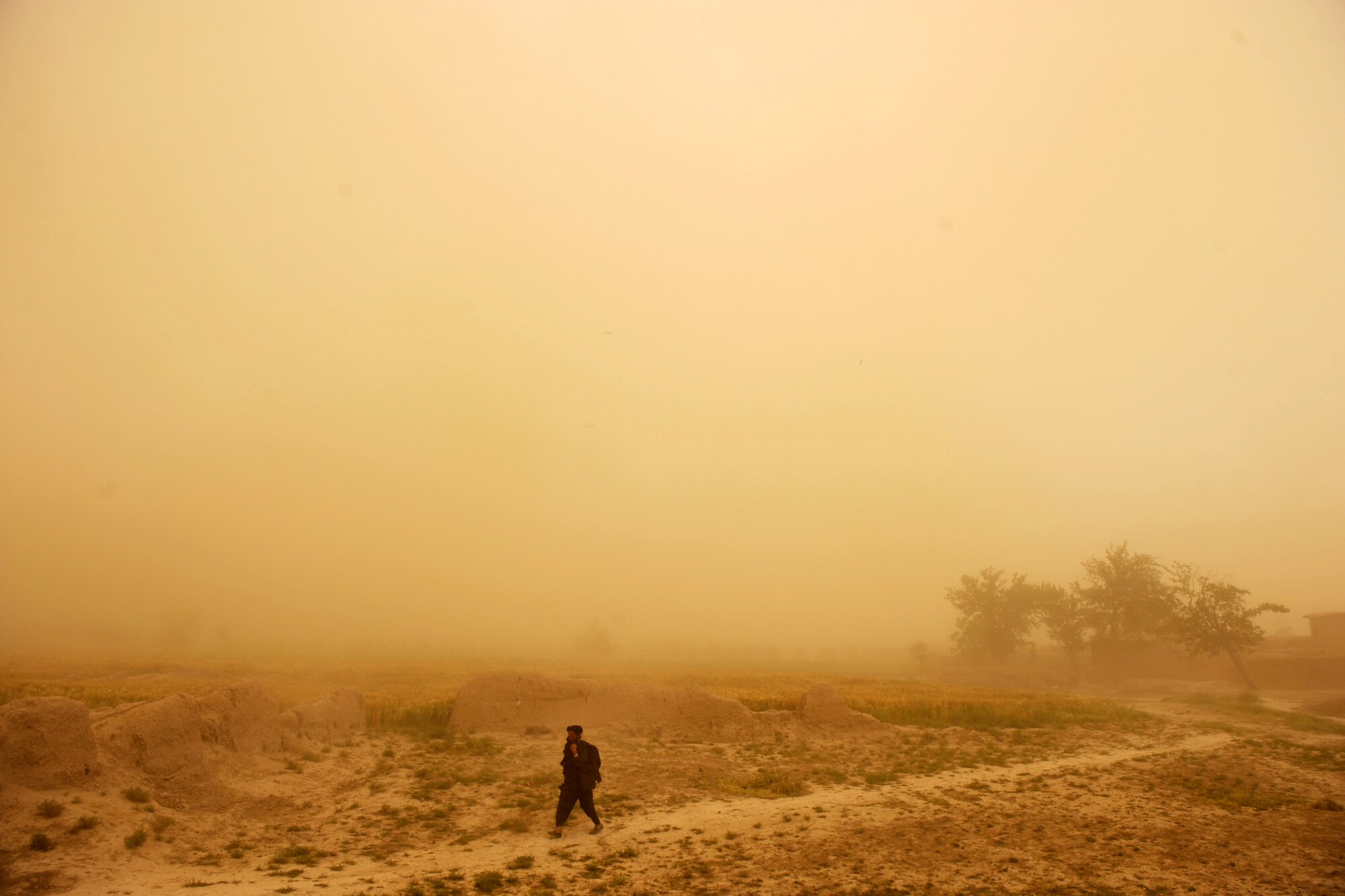 An Afghan man walks thru a dust storm May 22, 2010, near Omarkhel Village, Afghanistan. (U.S. Air Force photo/Staff Sgt. Manuel J. Martinez/released) 
