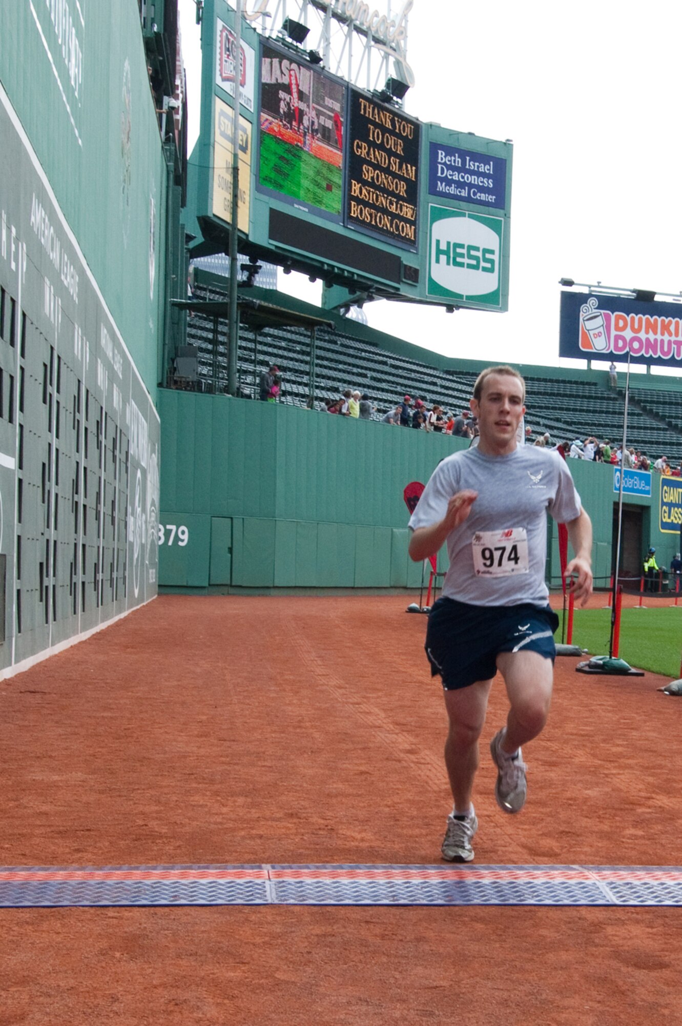 BOSTON – 1st Lt. Ronald Jenkins, 350th Electronic Systems Group, crosses the finish line near home plate at Fenway Park. Lieutenant Jenkins was the 14th finisher of more than 2,000 runners.  He finished the race with a time of 35:13. The race began at Fenway Park, crossed the Massachusetts Avenue Bridge, wound along the Charles River and returned over the bridge and into the ballpark, finishing at home plate.  Friends and supporters were invited into the park to watch their runner finish the race.  (U.S. Air Force photo by Rick Berry)