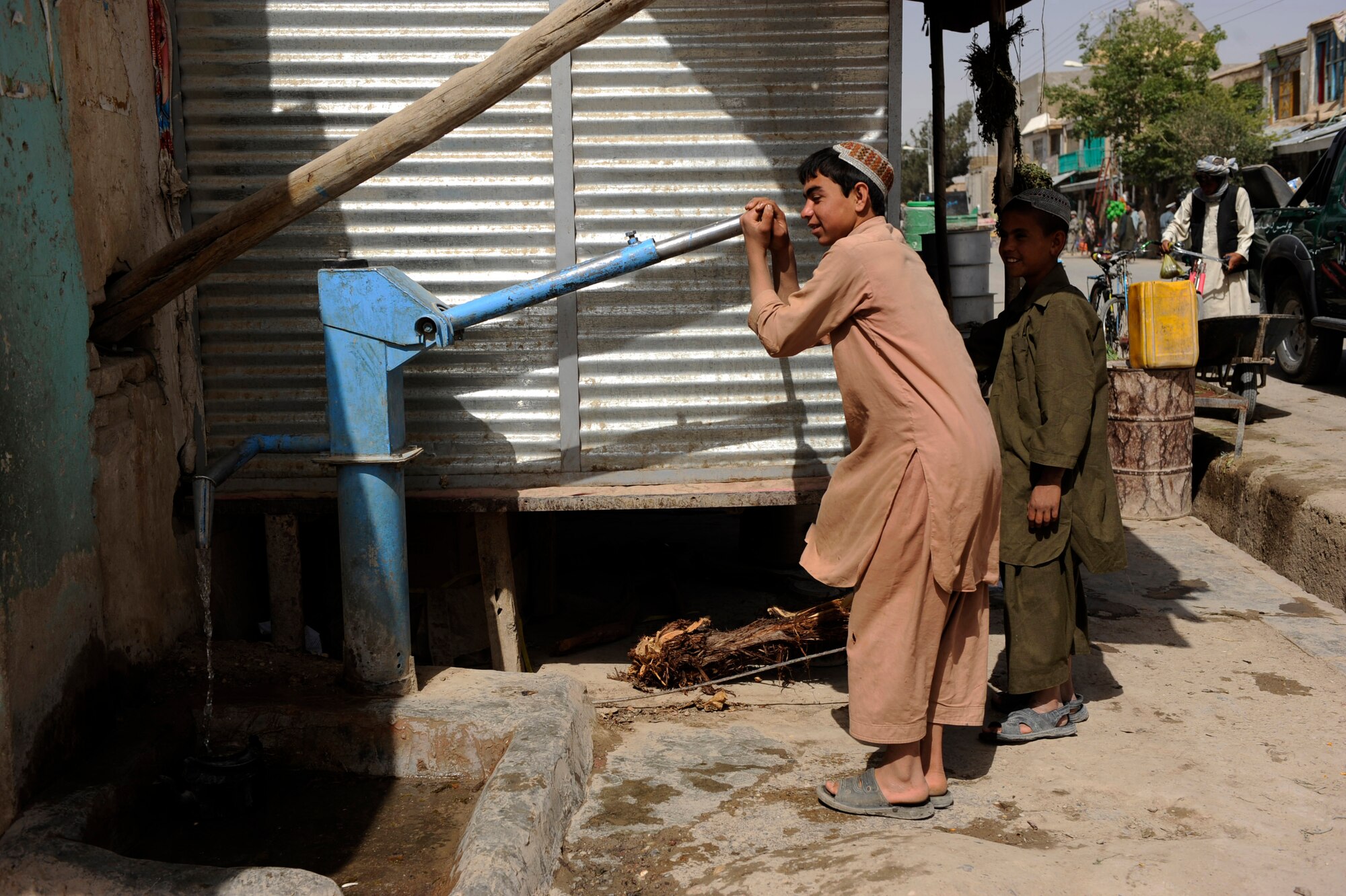 Afghan boys pump water on a bazaar street during a foot patrol by Provincial Reconstruction Team Zabul Airmen and Soldiers May 23, 2010, in Qalat City, Afghanistan. PRT Airmen help facilitate projects like Clean Water, a program that provides Afghan families chlorine to kill bacteria in local water (U.S. Air Force photo/Staff Sgt. Manuel J. Martinez/released) 