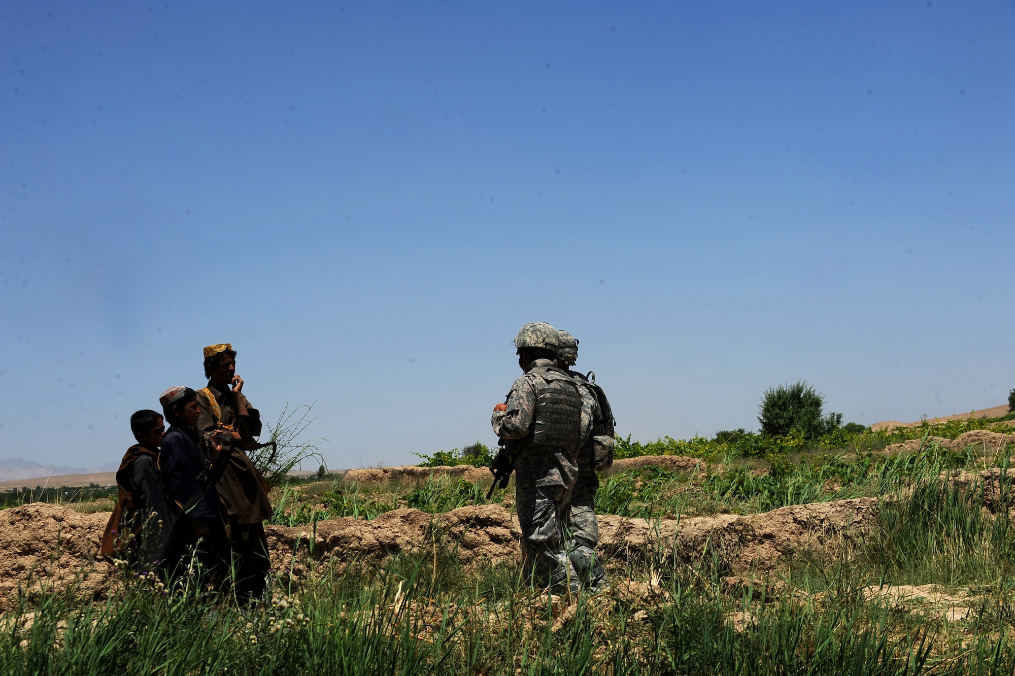 Tech. Sgt. Christopher Loar, information operations NCOIC assigned to Provincial Reconstruction Team Zabul, asks a group of Afghan boys if they had seen any Afghan National Police in the area, May 24, 2010, near Khaleqdad Khan, Afghanistan. (U.S. Air Force photo/Staff Sgt. Manuel J. Martinez/released) 

