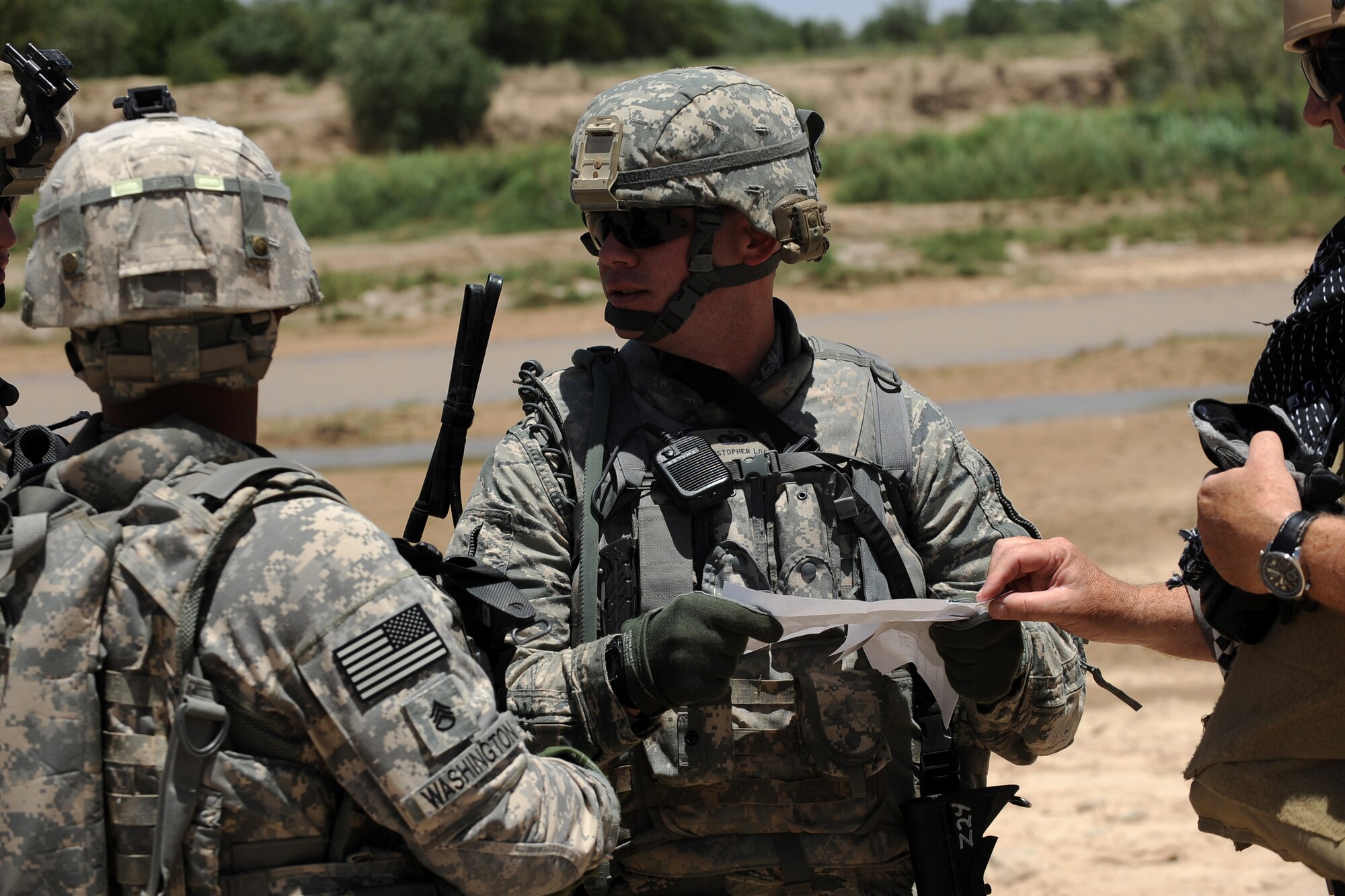 Tech. Sgt. Christopher Loar, information operations NCOIC assigned to Provincial Reconstruction Team Zabul, speaks with Army Staff Sgt. Clarence Washington, PRT Zabul security forces, 3rd squad lead, about meeting up with Afghan National Police prior entering a village for a Shura, May 24, 2010, near Khaleqdad Khan, Afghanistan. (U.S. Air Force photo/Staff Sgt. Manuel J. Martinez/released) 