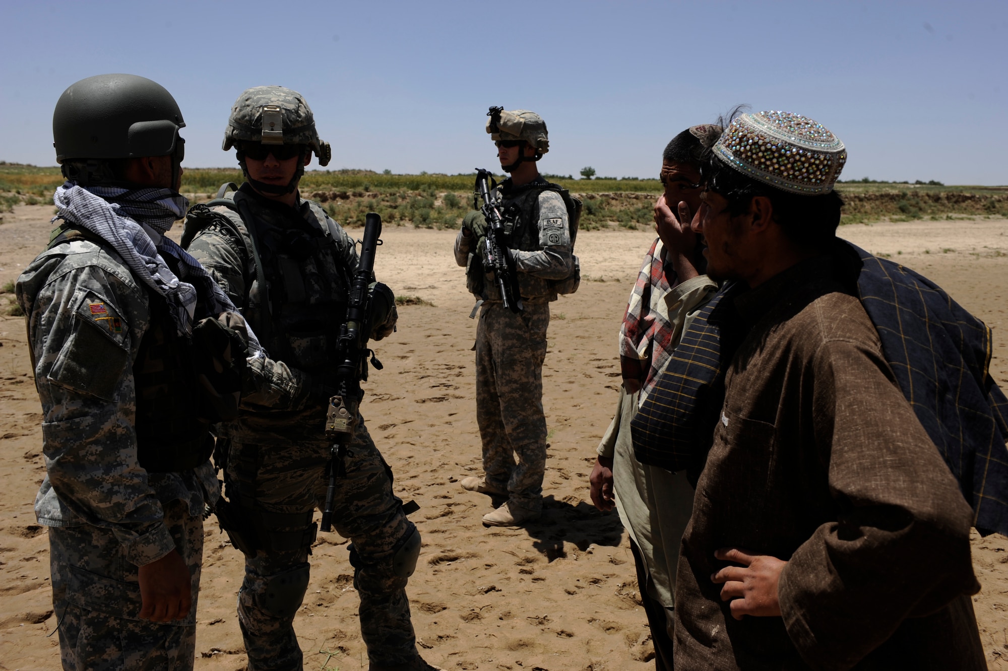 Tech. Sgt. Christopher Loar, information operations NCOIC assigned to Provincial Reconstruction Team Zabul, asks a group of Afghan men if they had seen any Afghan National Police in the area, May 24, 2010, near Khaleqdad Khan, Afghanistan. Since PRT Zabul?s implementation of Operation Wroorwali the team has conducted four Shuras throughout Zabul Province. (U.S. Air Force photo/Staff Sgt. Manuel J. Martinez/released) 
