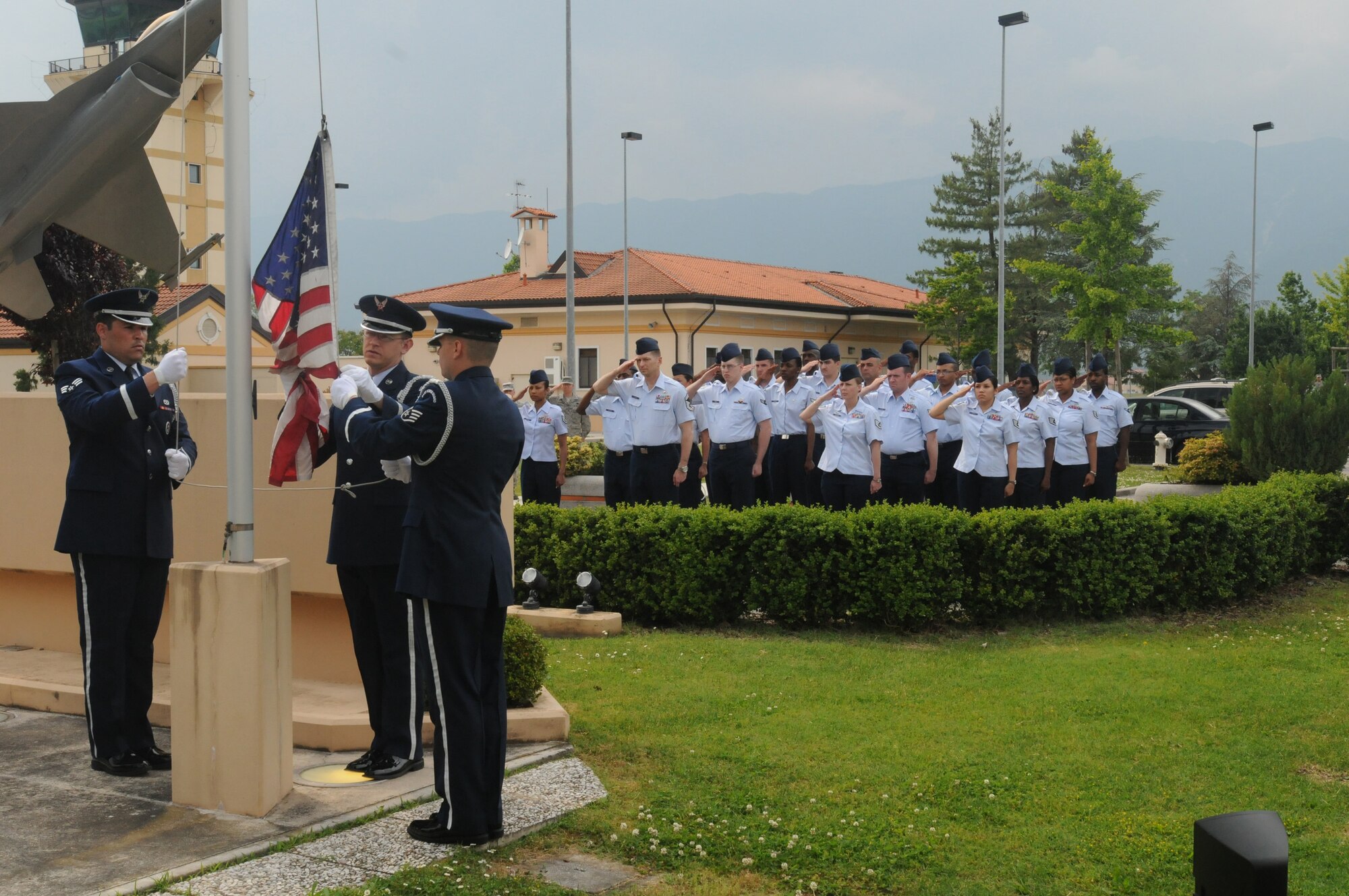 Airmen salute during a Memorial Day retreat ceremony as Honor Guard members slowly lower the American Flag May 28. More than 40 people assisted in performing this ceremony as a way to respect and honor the members of the armed forces who have died while in military service. (U.S. Air Force photo/ Airman LaVel Sterling)